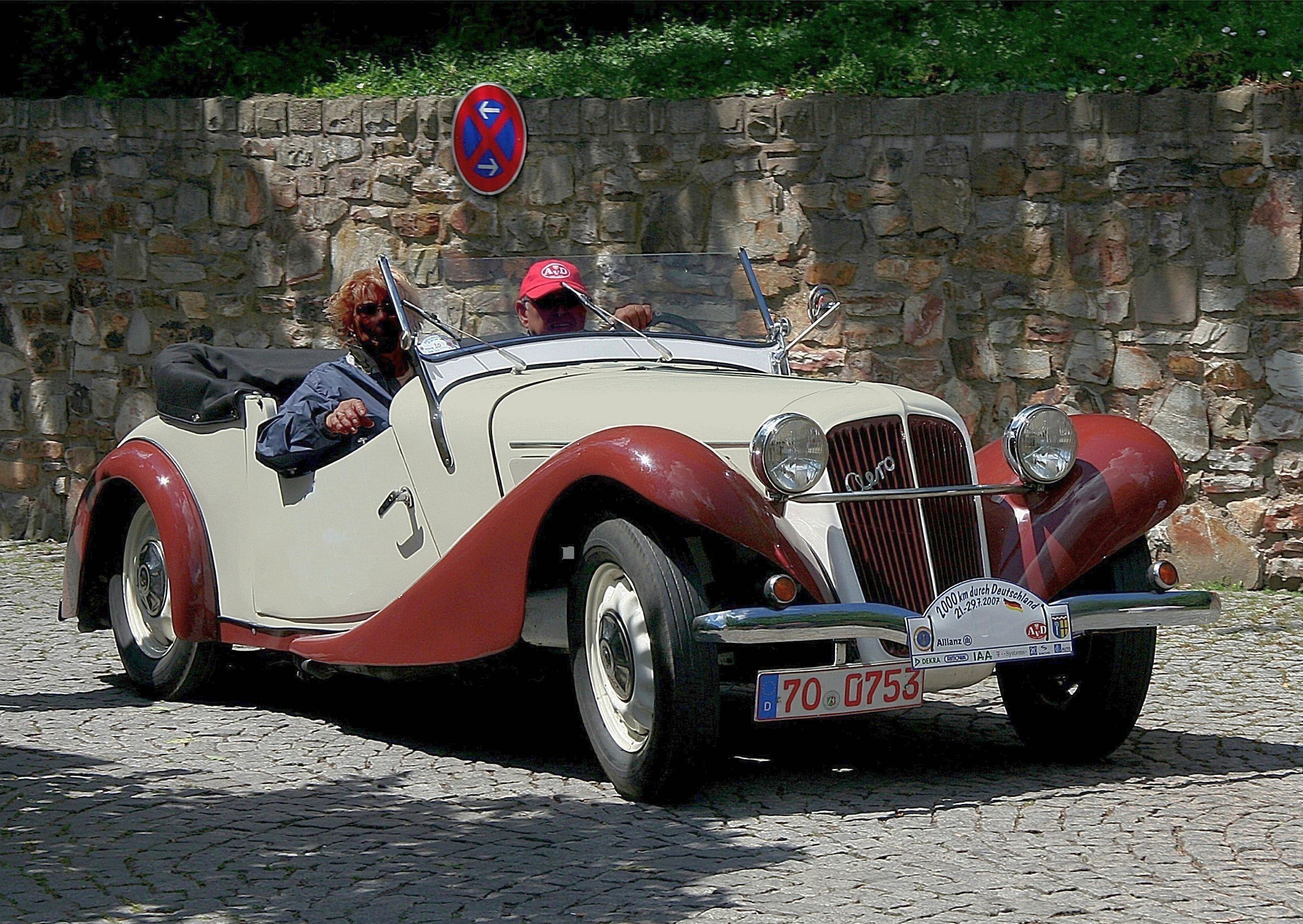 Cream and red 1936 Aero 30 roadster in motion, front three-quarter view