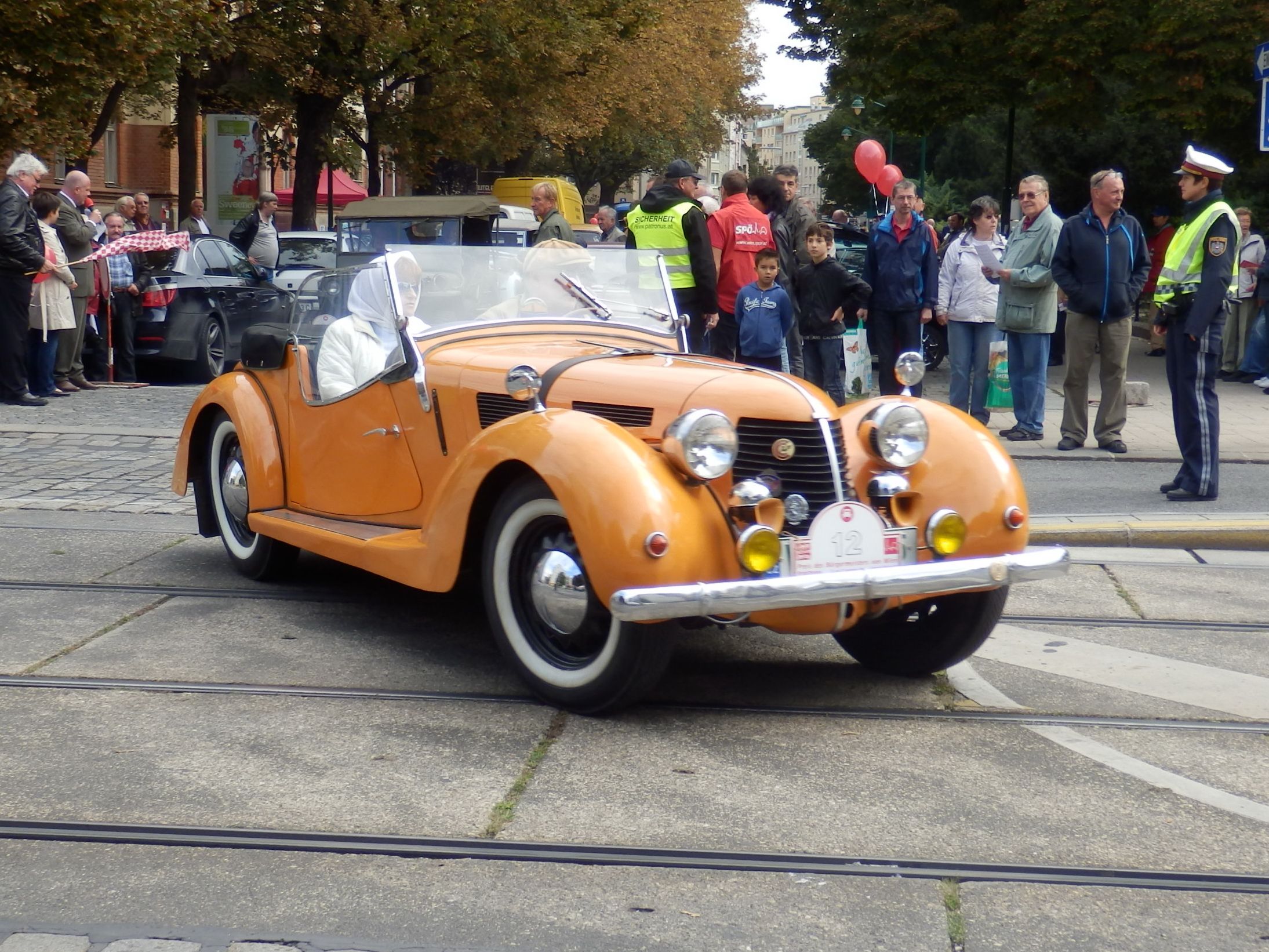 Orange 1939 Aero 30 Sodomka roadster at a rally, front three-quarter view
