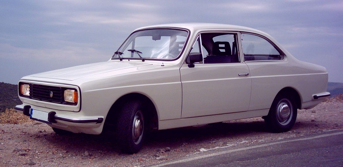 White 1974 Anadol A1 MkII two-door coupé on a hillside road, front three-quarter view
