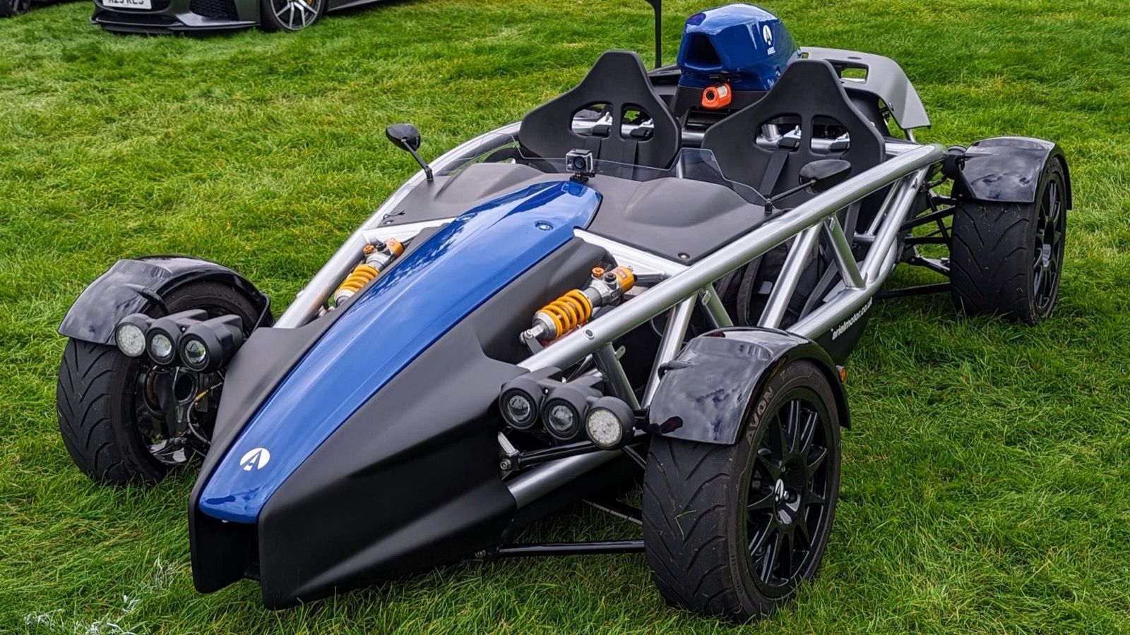 Blue and black Ariel Atom 4 with curved tubular exoskeleton, front three-quarter view