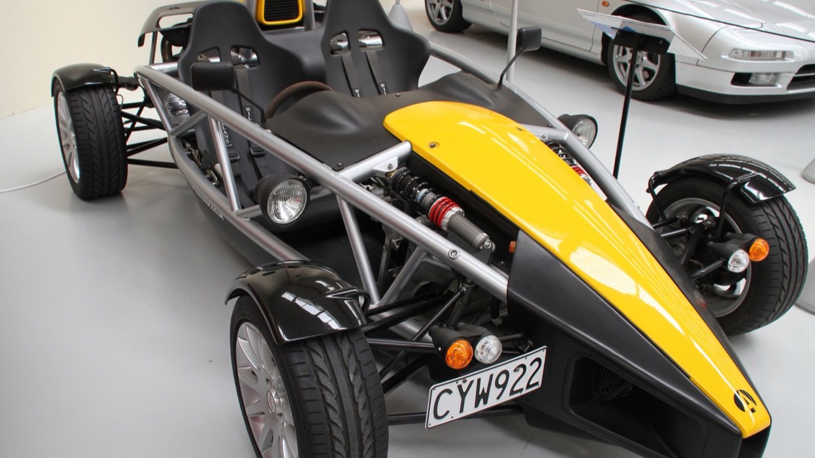 Yellow and black Ariel Atom 2 with exposed tubular chassis, front three-quarter view