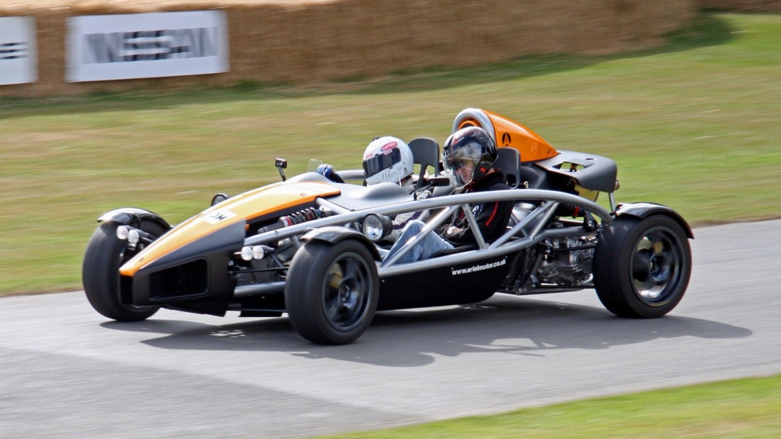 Orange and black Ariel Atom 3 on a hill-climb course, front three-quarter view