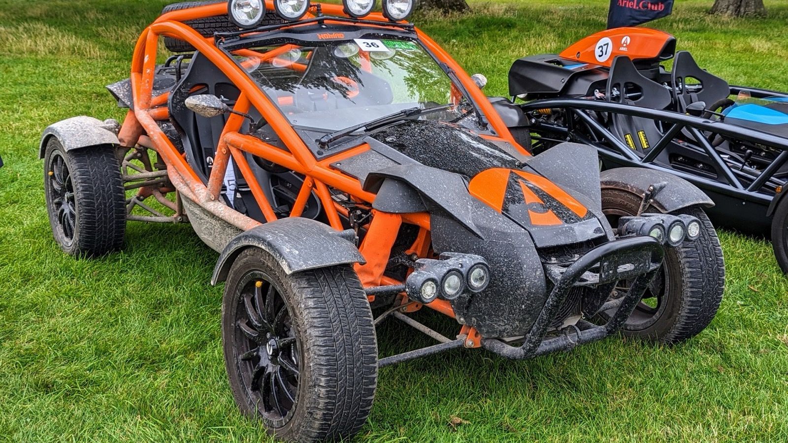 Orange Ariel Nomad off-road buggy with roll cage and knobbly tyres, front three-quarter view