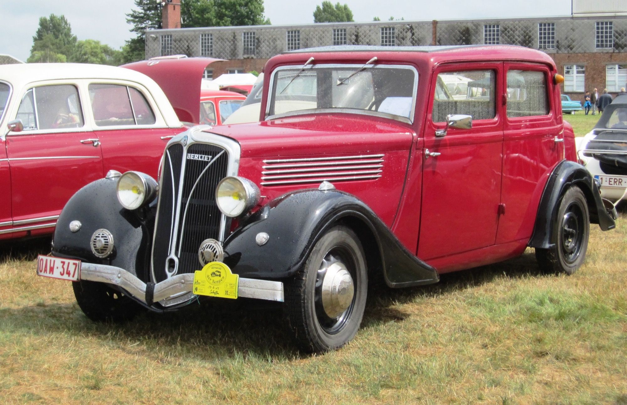 Red and black circa-1936 Berliet Dauphine berline saloon, front three-quarter view