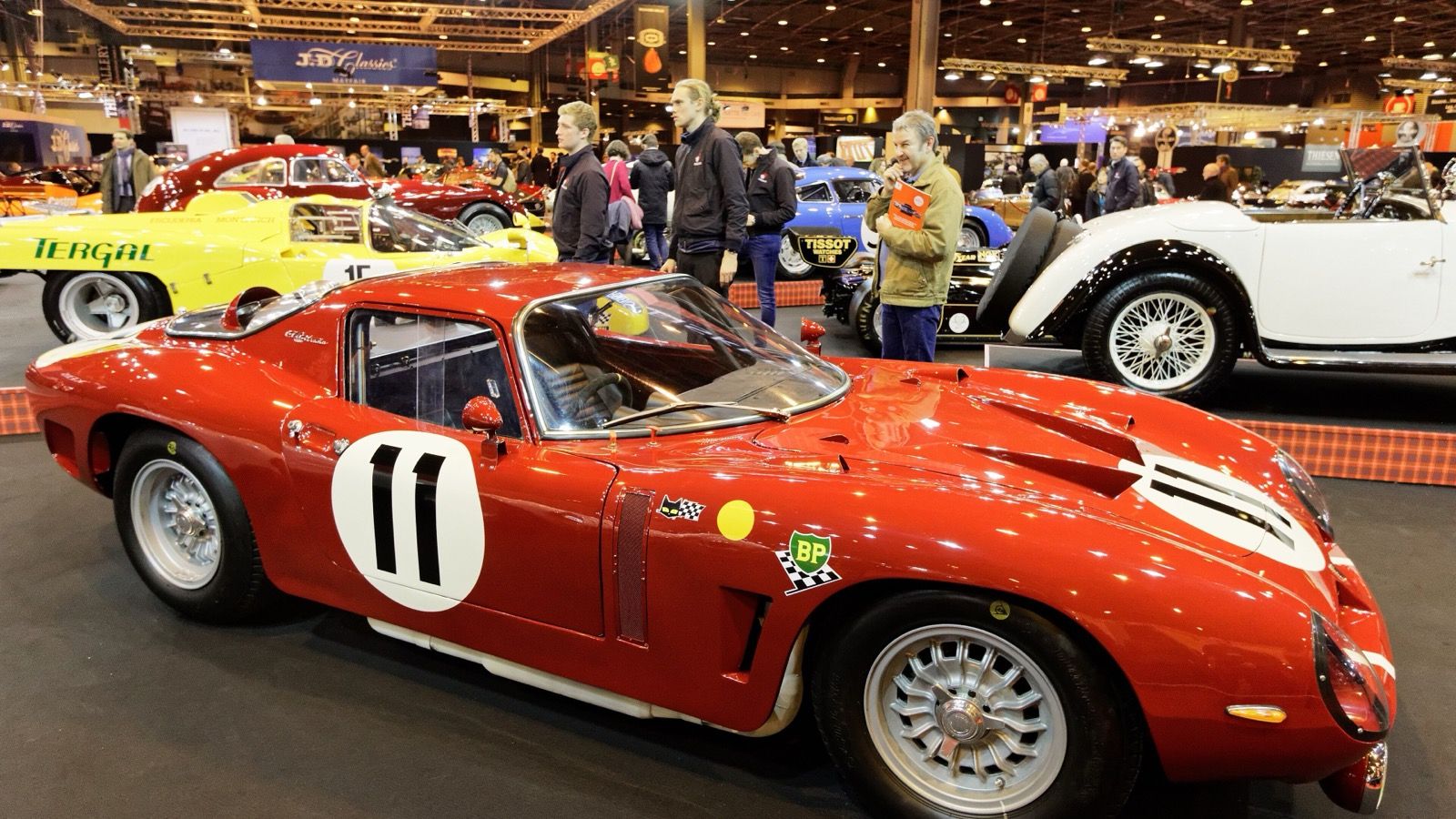 Red 1966 Bizzarrini competition coupé on display, side profile view