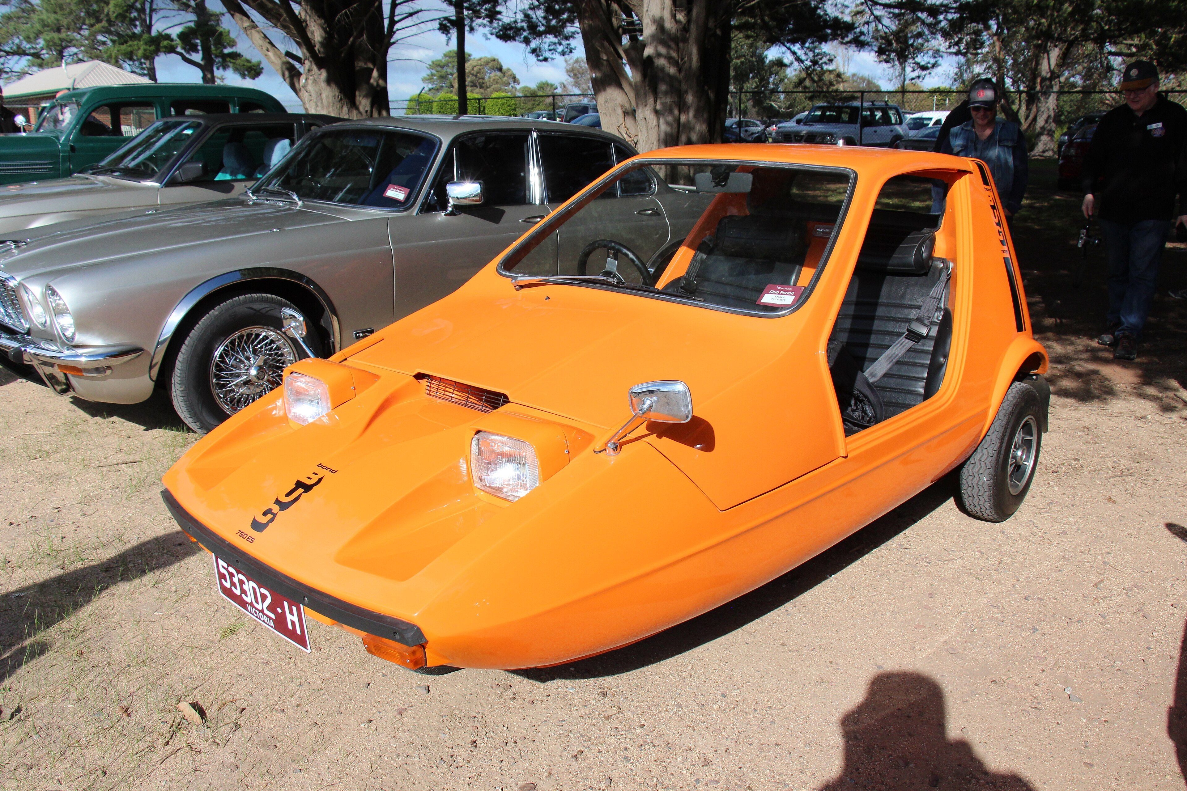 Tangerine orange Bond Bug 750ES wedge-shaped three-wheeler, front three-quarter view