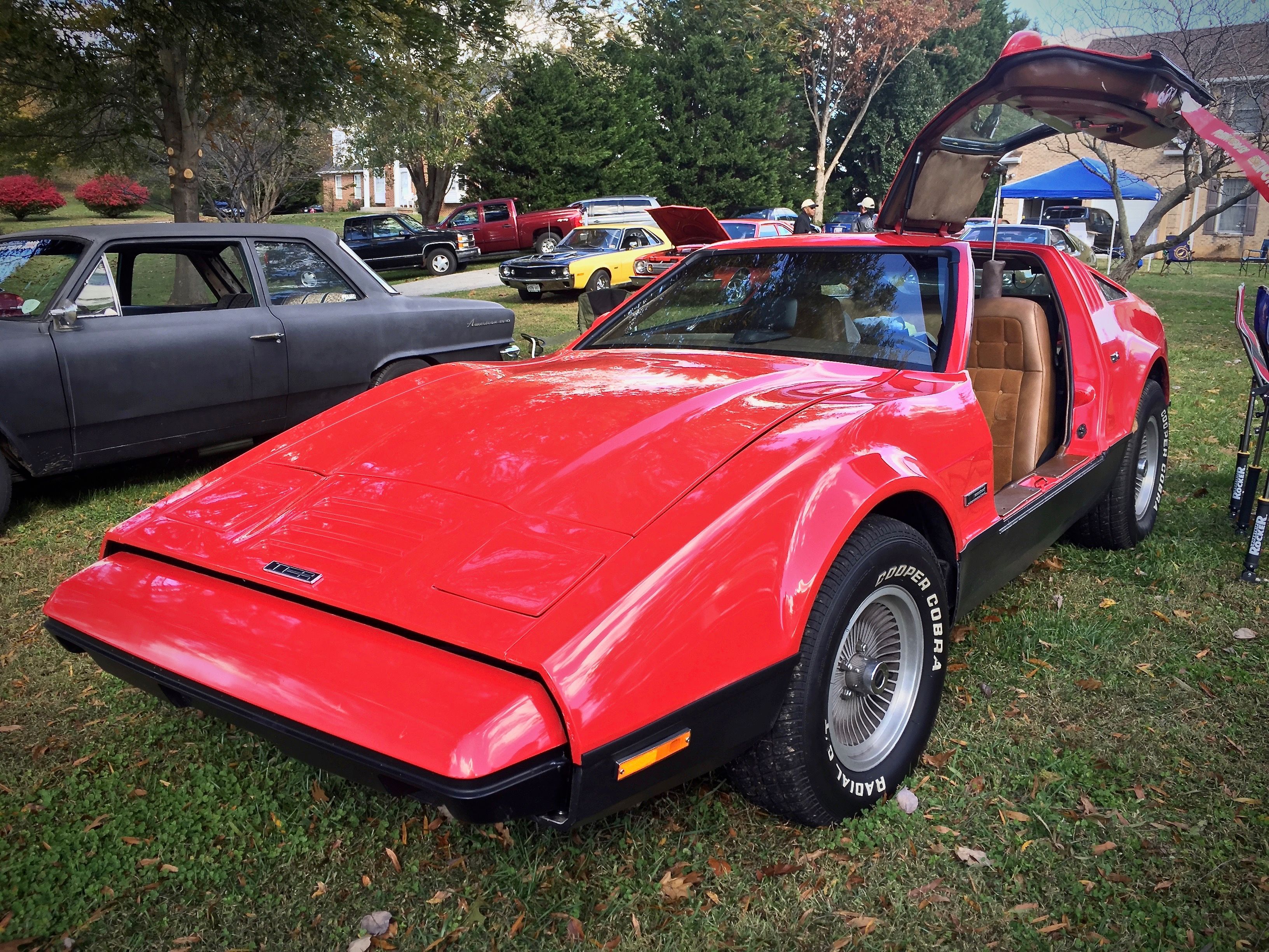 Red 1974 Bricklin SV-1 with a gull-wing door raised, front three-quarter view