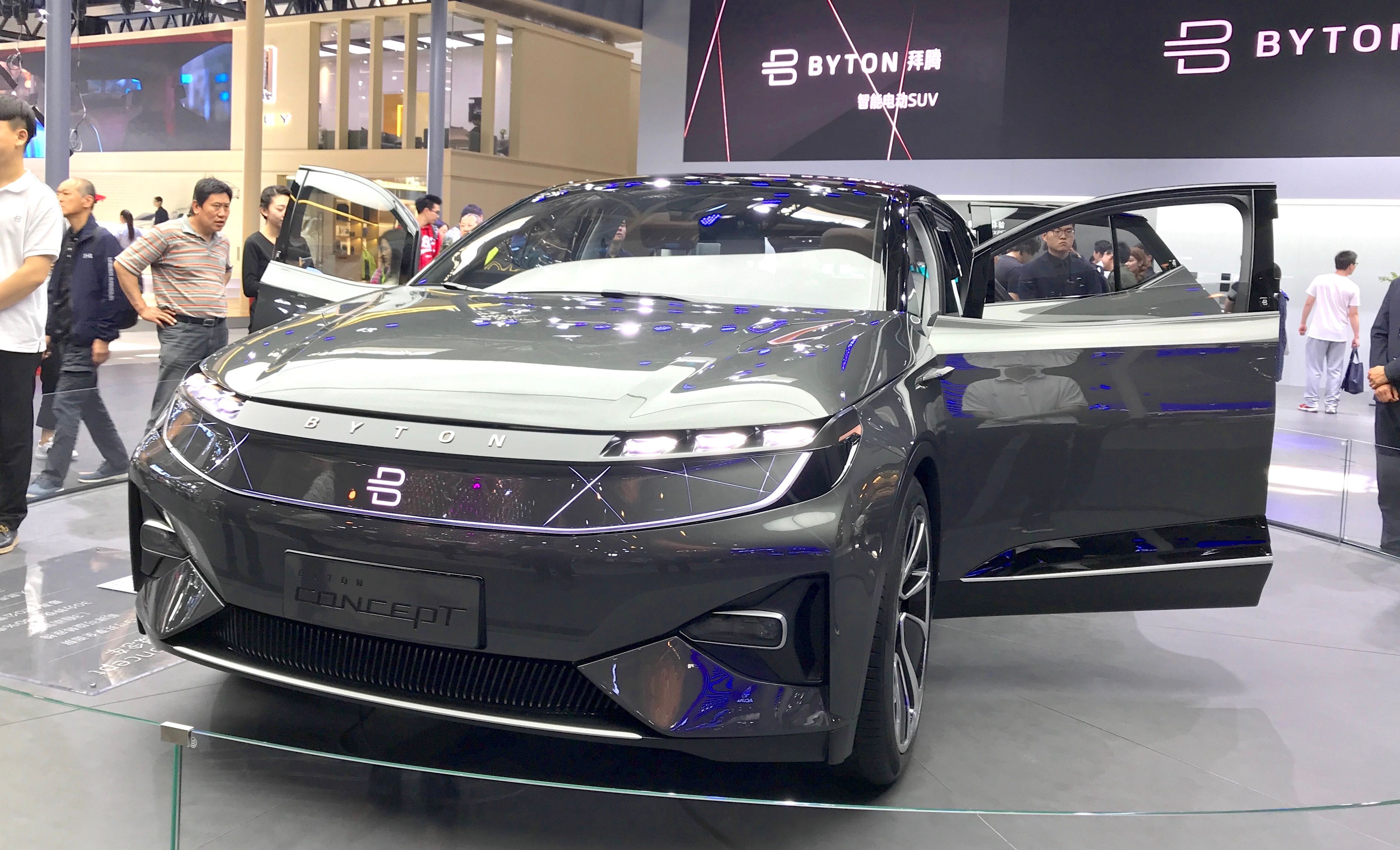 Grey Byton Concept electric SUV with doors open, front three-quarter view at an auto show