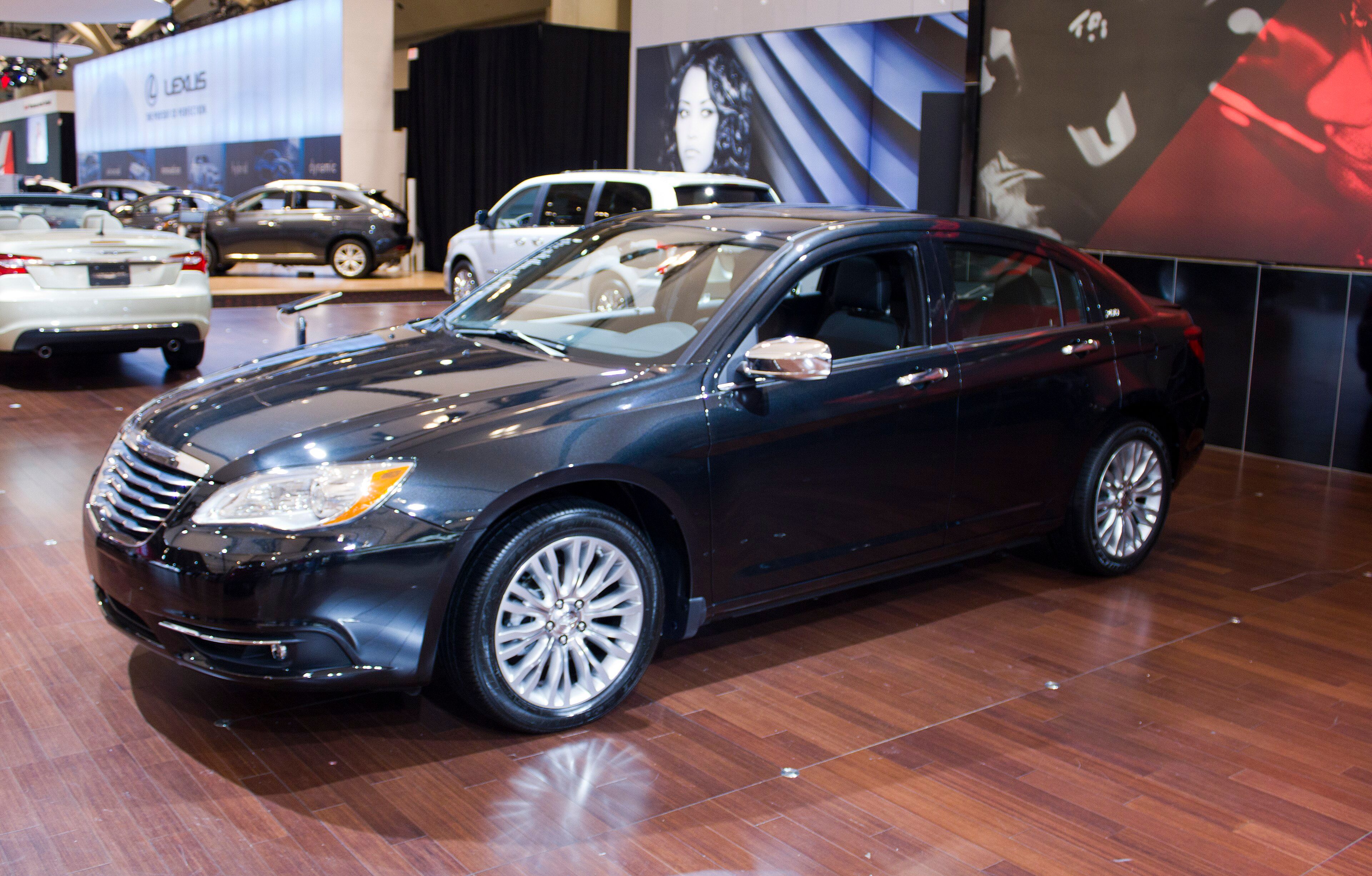Black 2011 Chrysler 200 Limited sedan on an auto-show stand, front three-quarter view