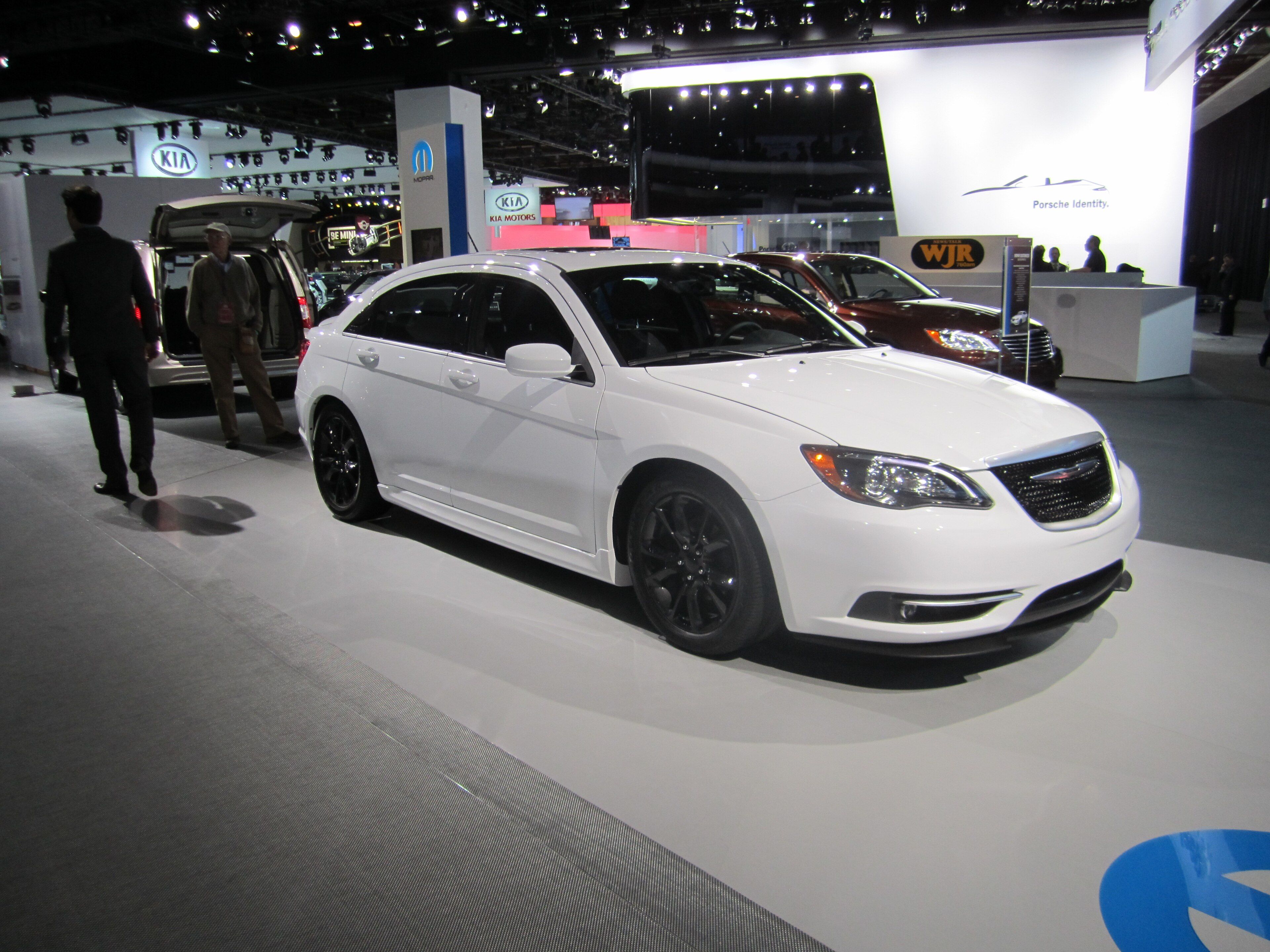 White 2012 Chrysler 200 Super S sedan on an auto-show stand, front three-quarter view