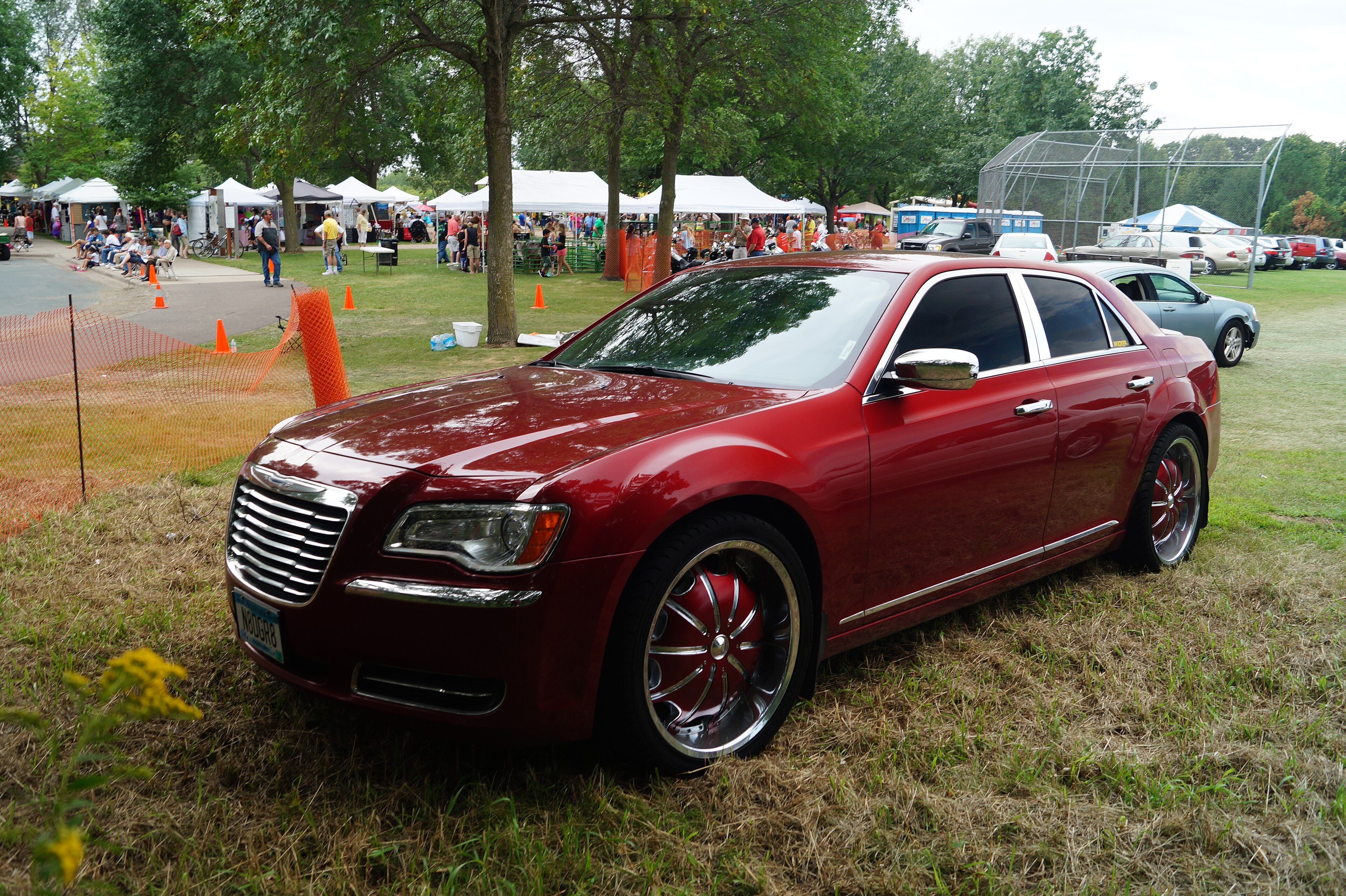 Dark red 2012 Chrysler 300 sedan at a car show, front three-quarter view