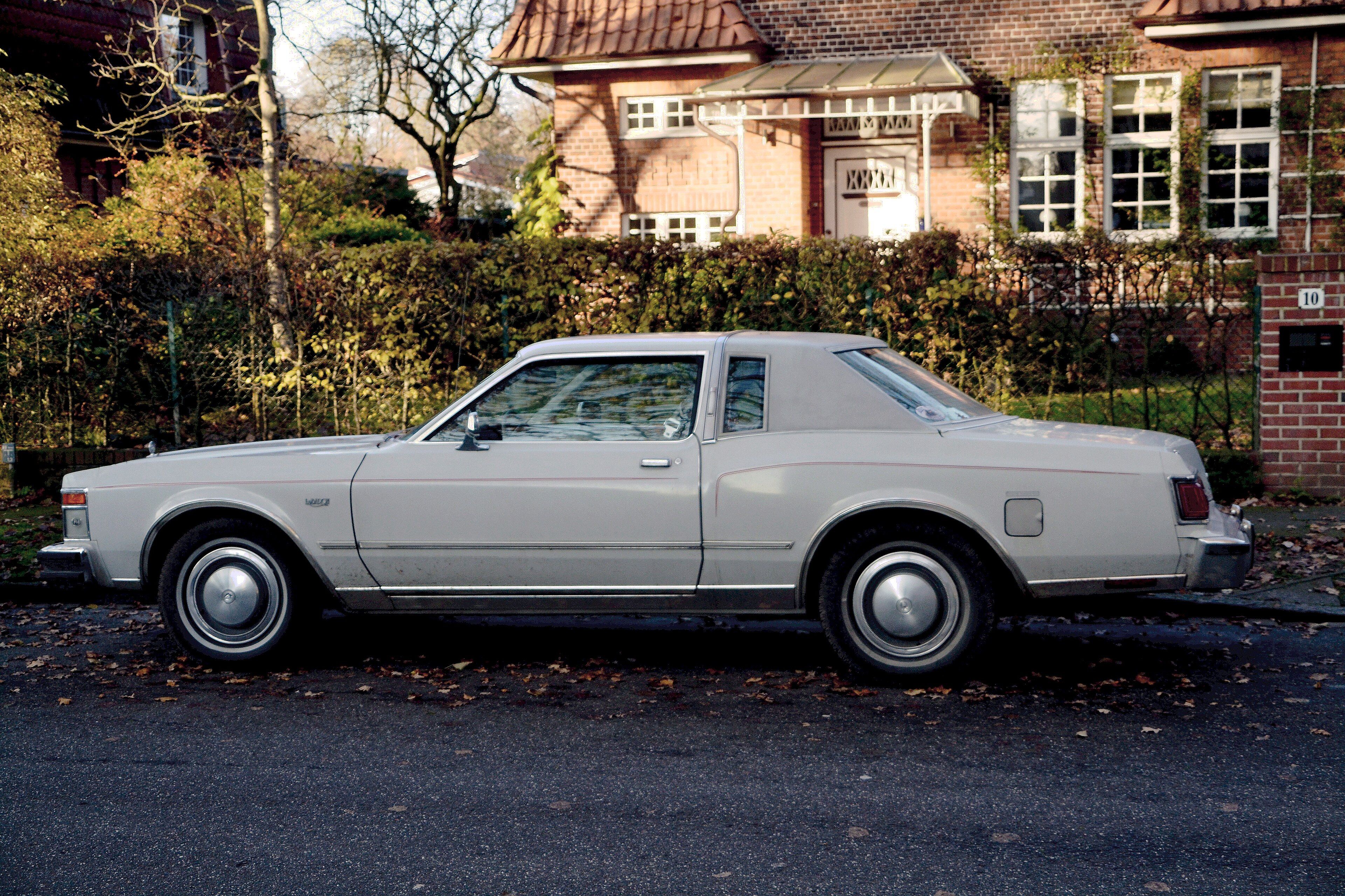 White 1979 Chrysler LeBaron coupe parked at a kerb, side profile view