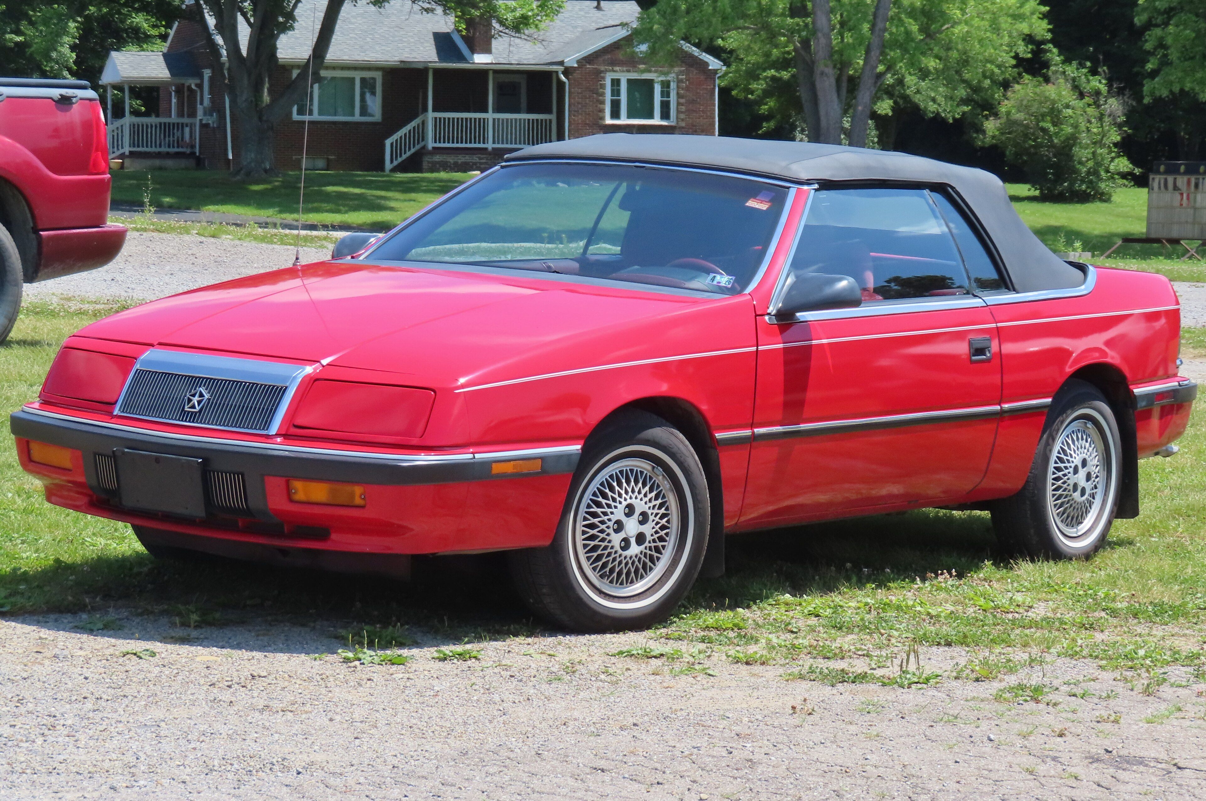 Red 1992 Chrysler LeBaron convertible with the top up, front three-quarter view