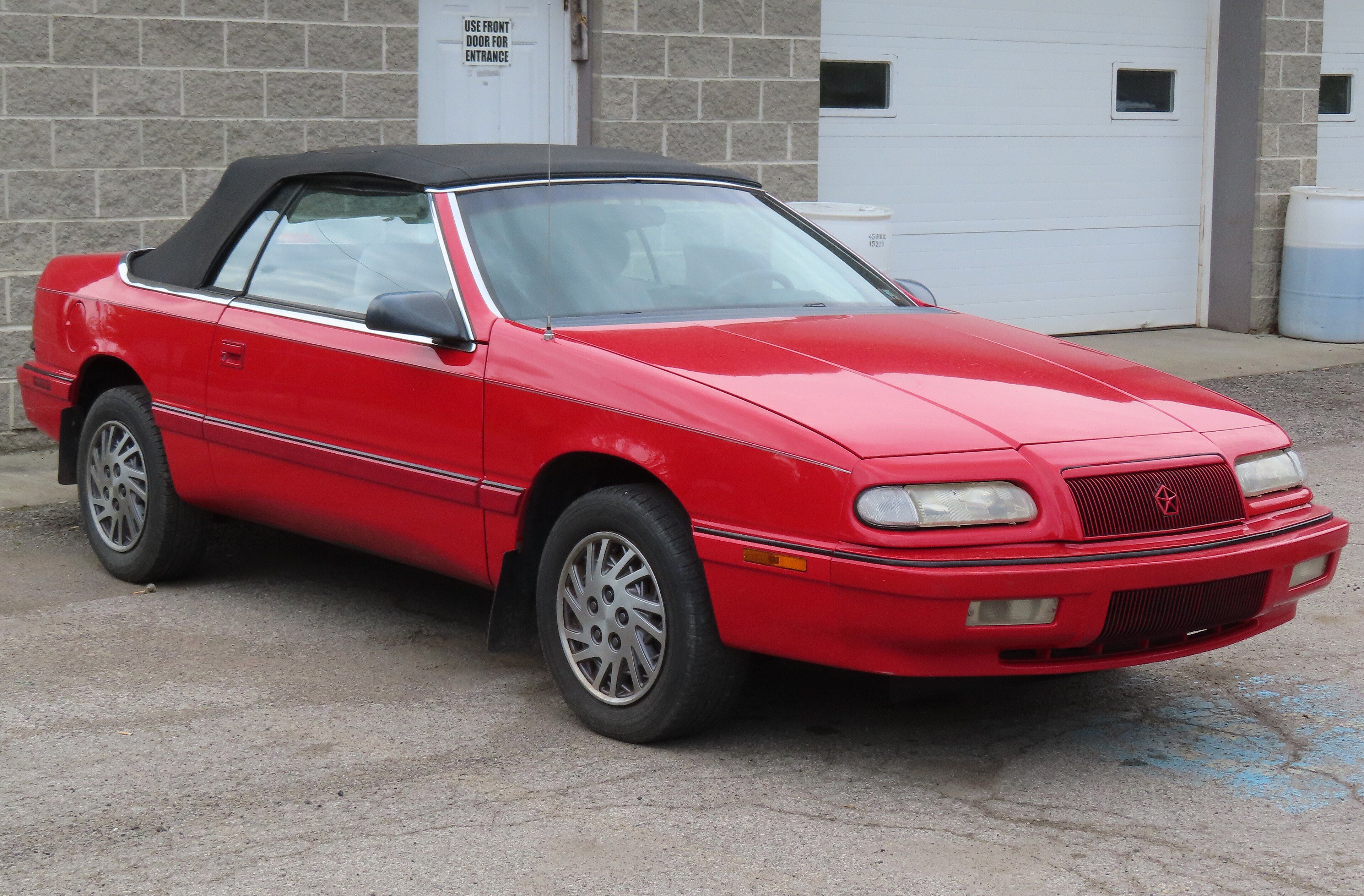 Red 1993 Chrysler LeBaron convertible with the top up, front three-quarter view