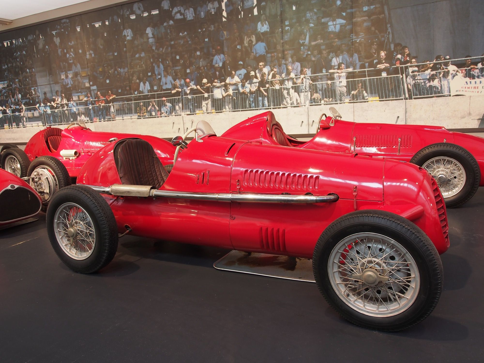 Red Cisitalia D46 single-seat racing car, side profile in a museum display