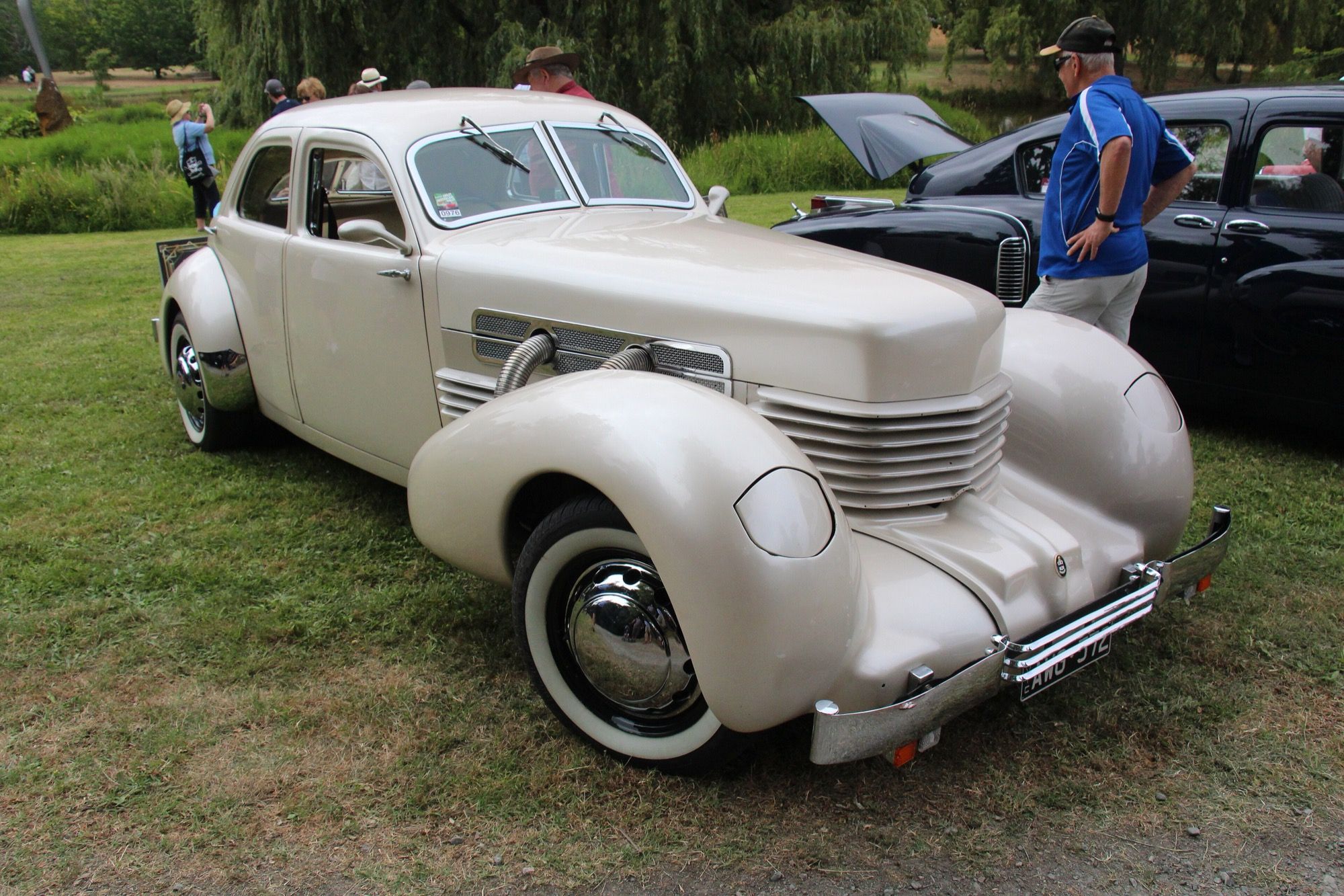 Cream 1936 Cord 810 Westchester sedan, front three-quarter view showing the coffin-nose wrap-around louvers