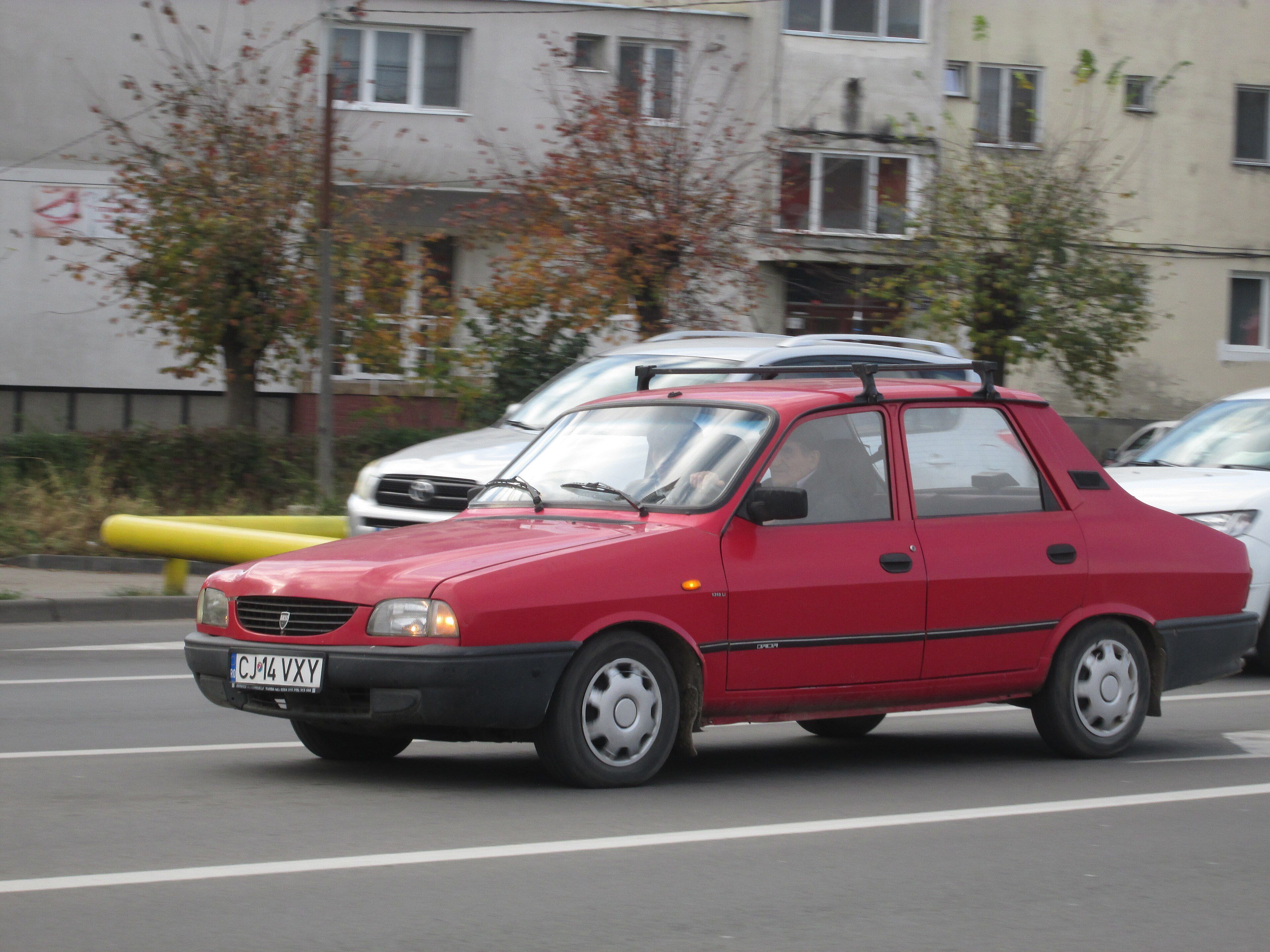 Red 2002 Dacia 1310 Li saloon in traffic, front three-quarter view