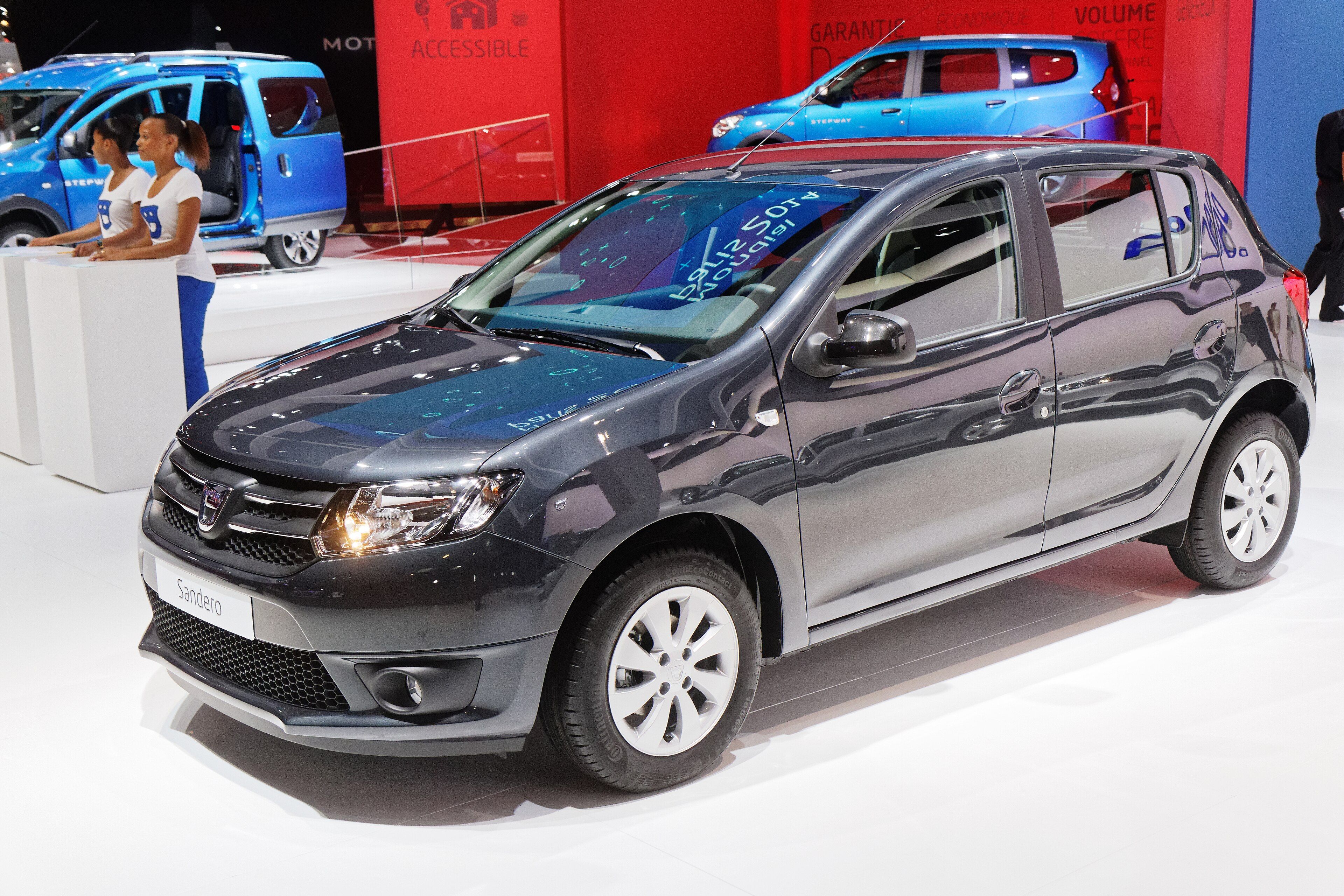 Dark grey second-generation Dacia Sandero on a motor-show stand, front three-quarter view