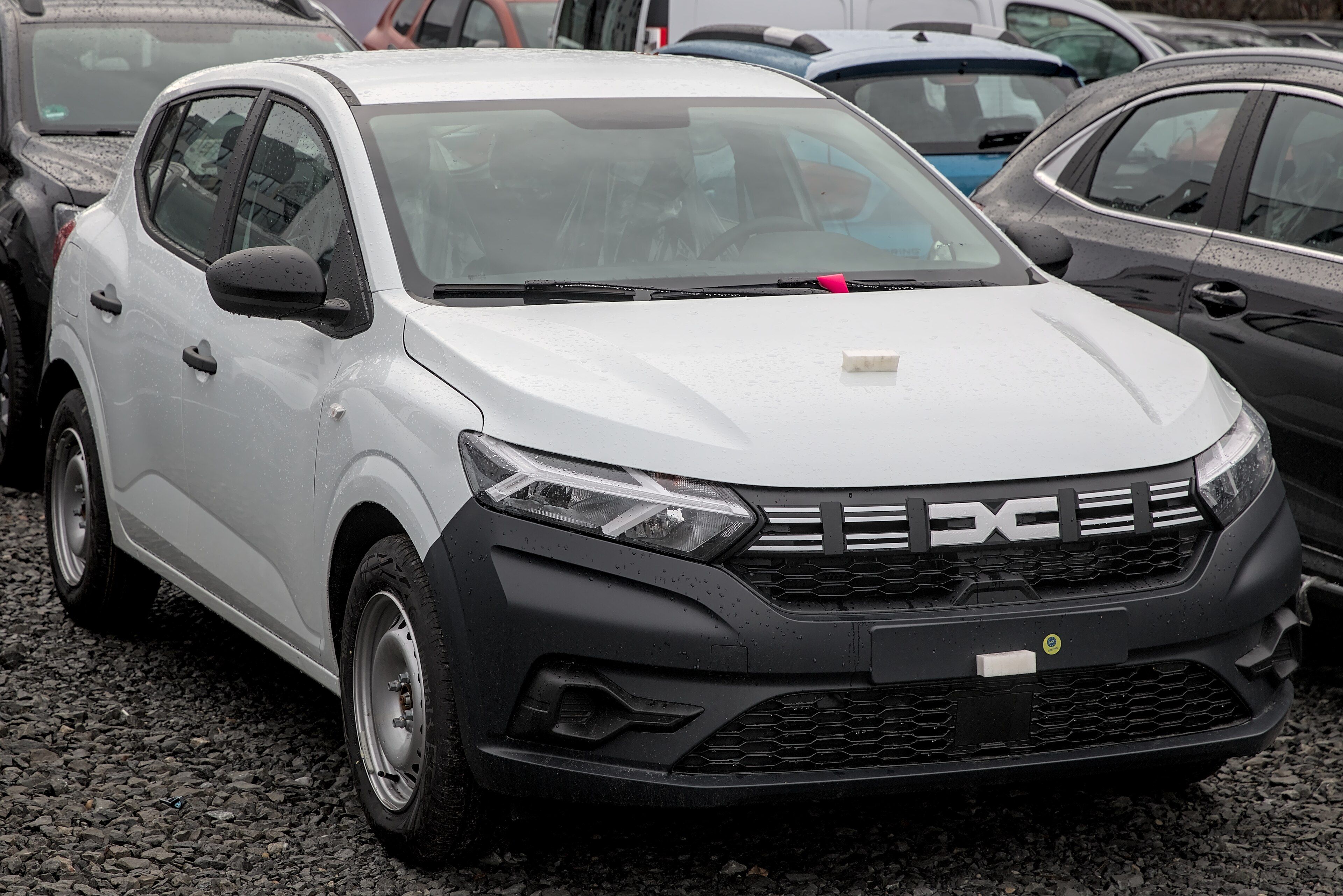 White third-generation Dacia Sandero hatchback with the new Dacia logo, front three-quarter view