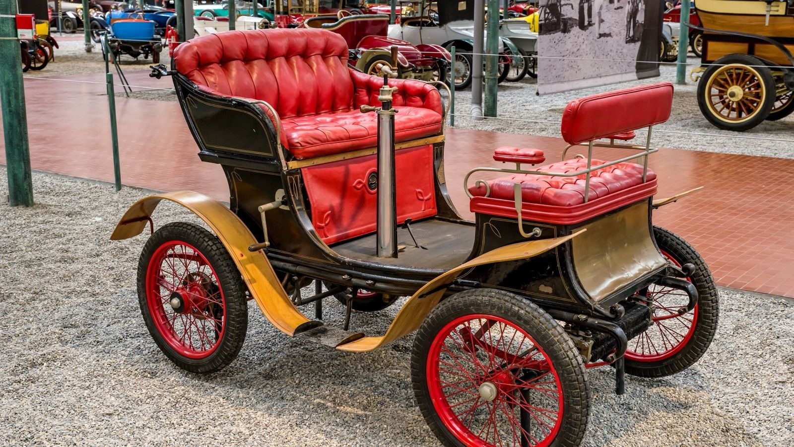 1900 De Dion-Bouton Type E vis-à-vis with red buttoned upholstery and red wire wheels, rear three-quarter view