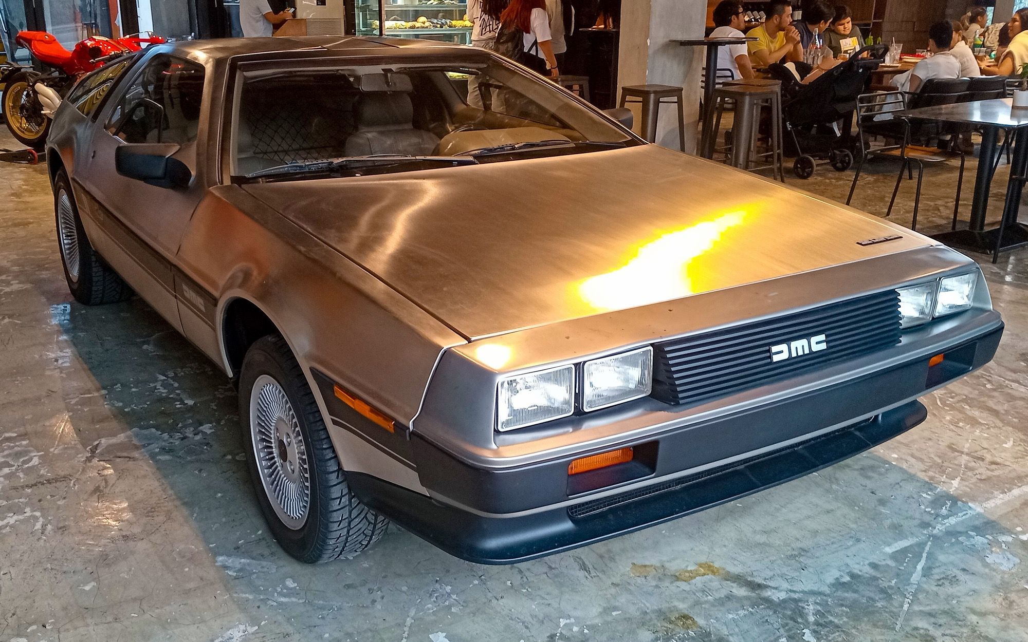 Brushed stainless-steel 1983 DeLorean DMC-12 coupe, front right three-quarter view