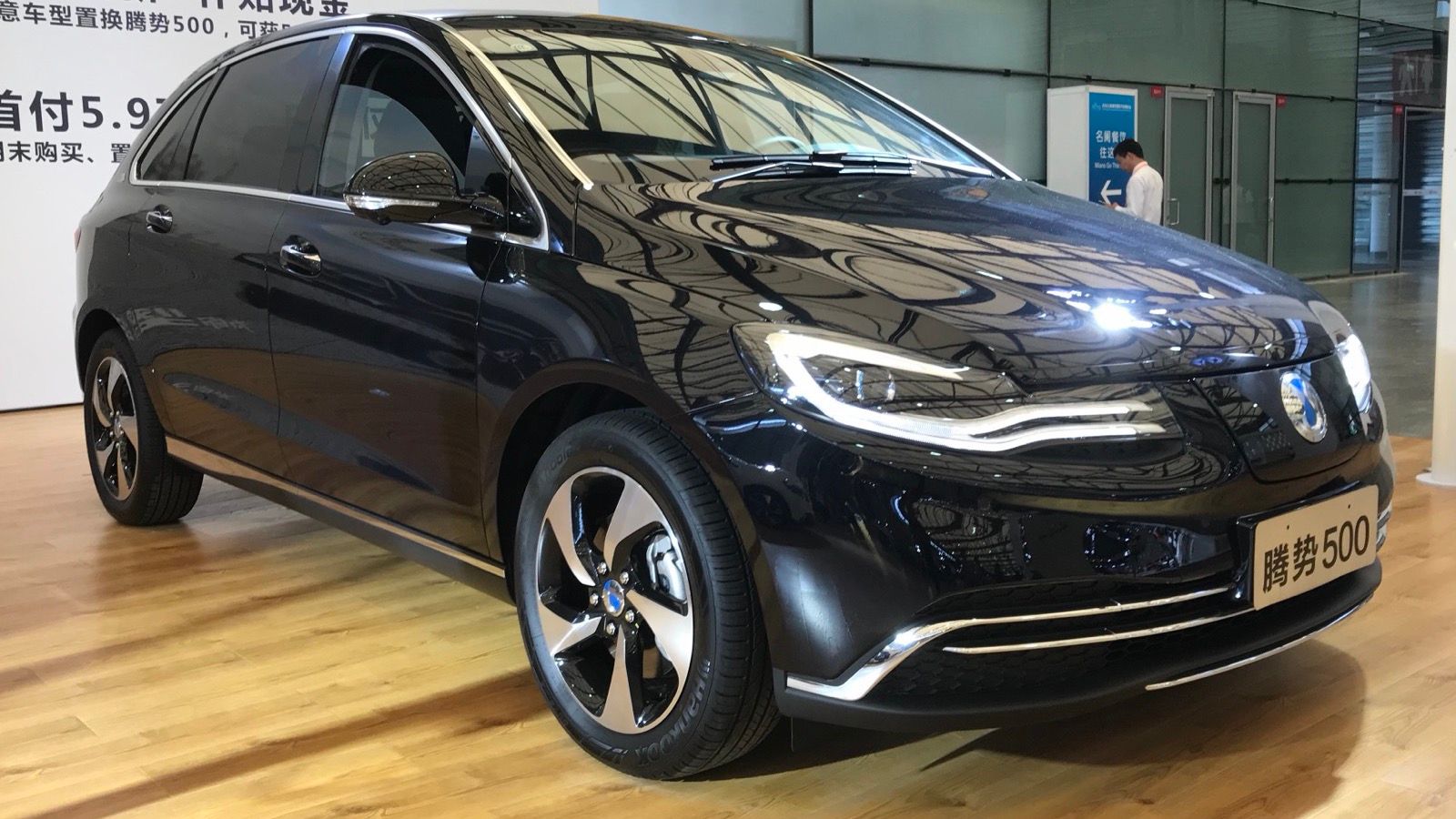 Black Denza 500 facelift on show stand, front three-quarter view