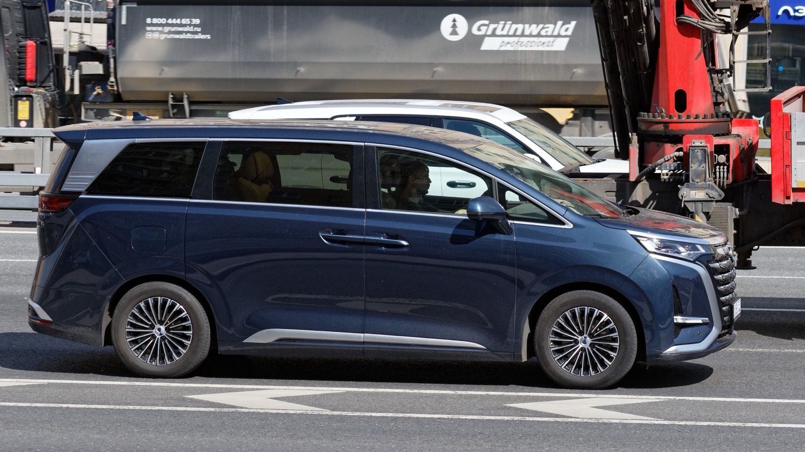 Dark blue Denza D9 minivan in Moscow traffic, side profile