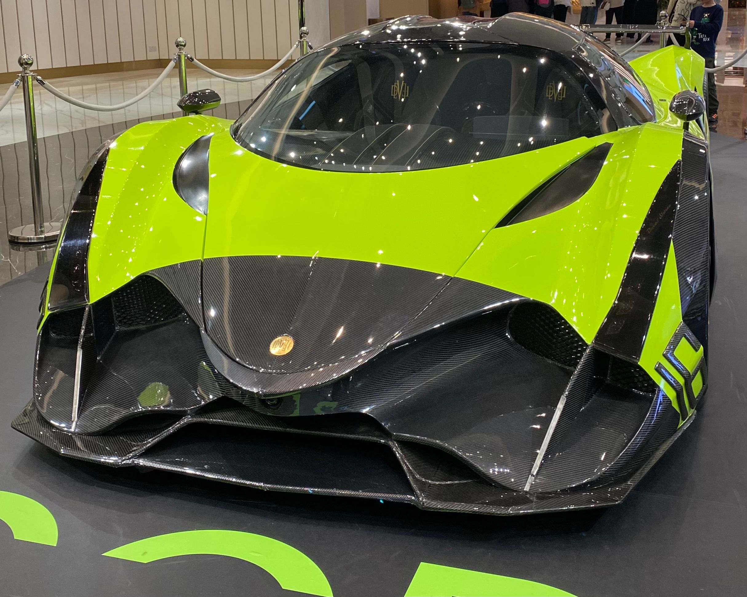 Lime-green and carbon-fibre Devel Sixteen on display, front three-quarter view