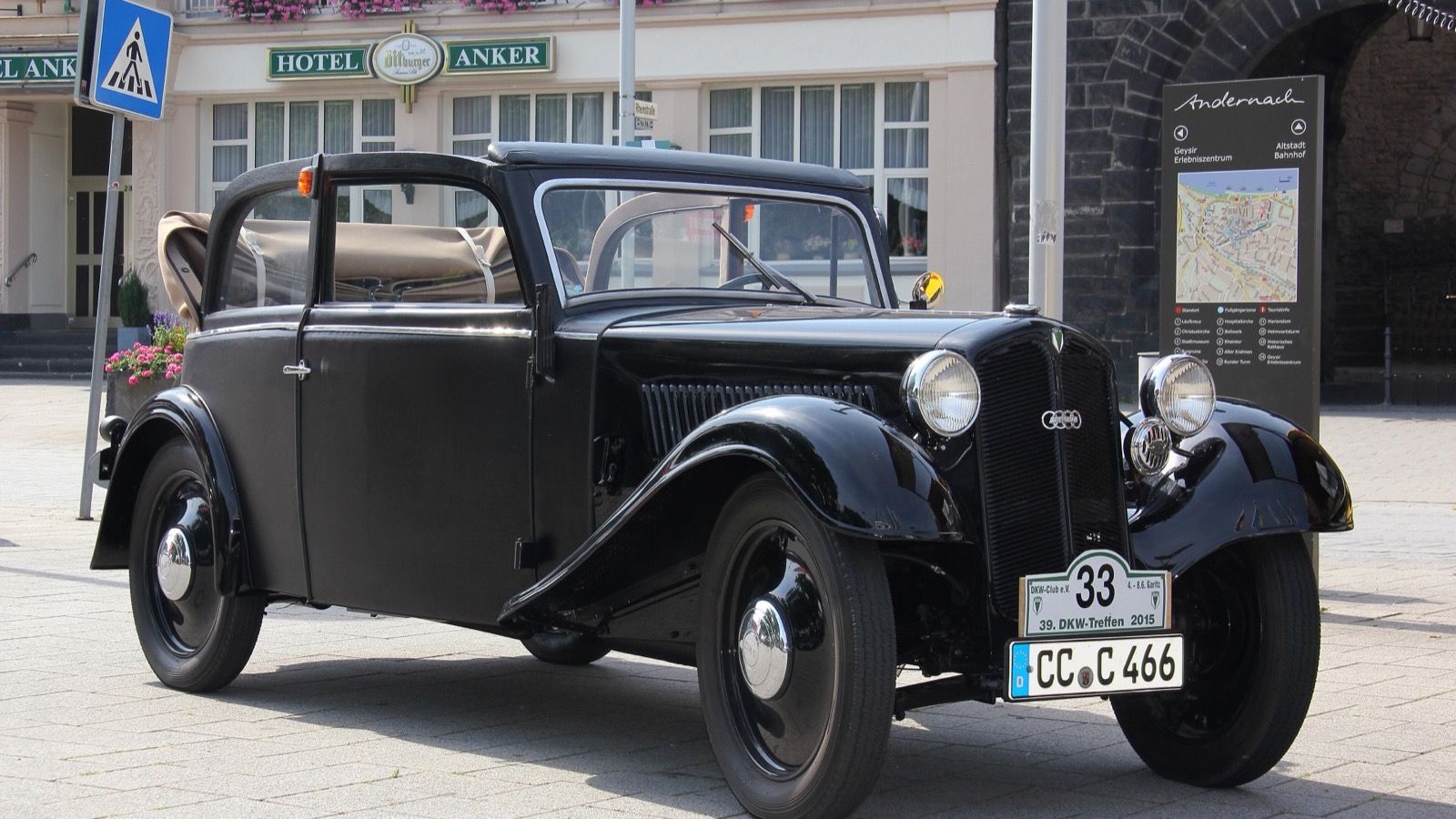Black 1936 DKW F5 Cabriolimousine parked in a town square, front three-quarter view