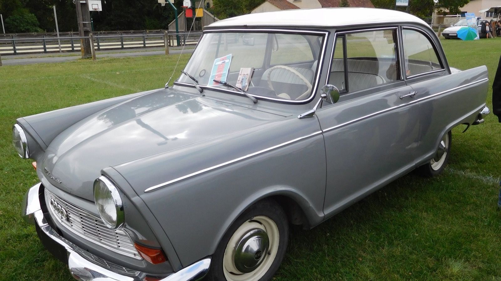 Grey 1962 DKW Junior de Luxe with white roof on grass, front three-quarter view