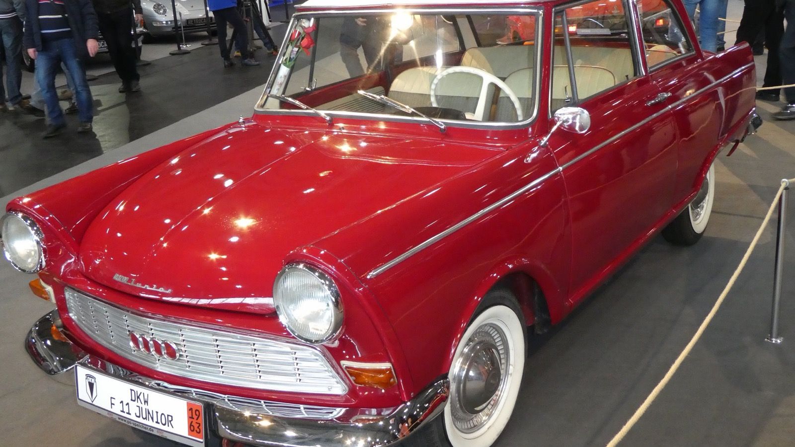 Dark red 1963 DKW F11 Junior de Luxe with white roof at an indoor show, front three-quarter view
