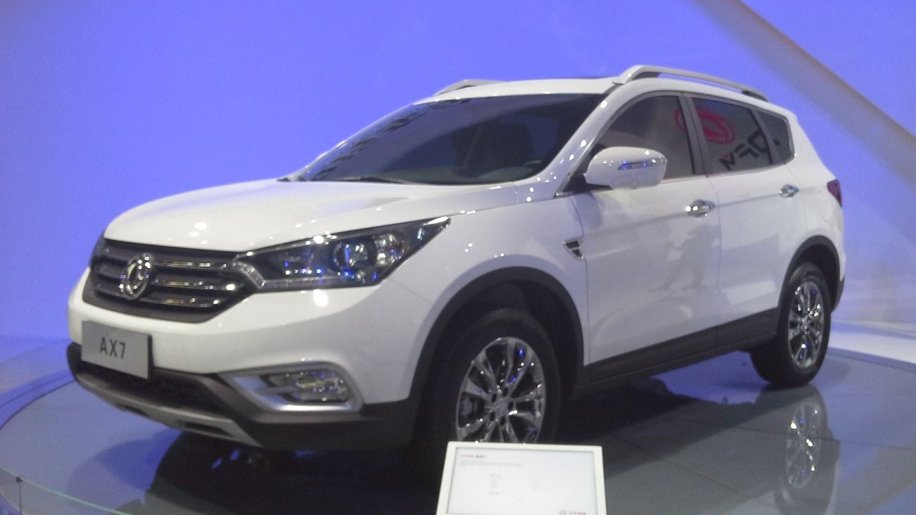 White Dongfeng Fengshen AX7 compact SUV on the Auto China show stand, front three-quarter view