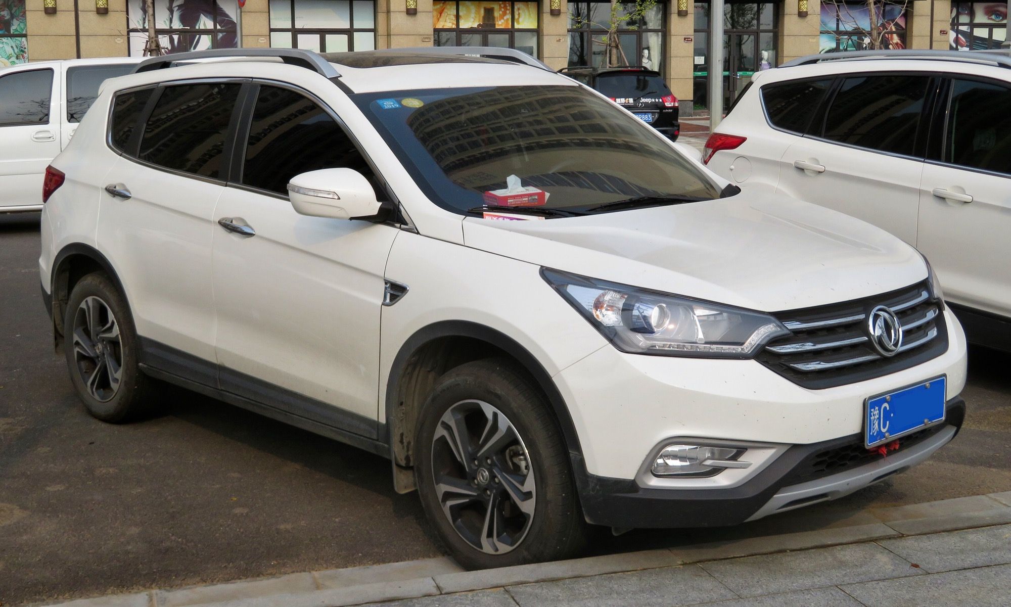 White 2017 Dongfeng Fengshen AX7 compact SUV parked on a street, front three-quarter view