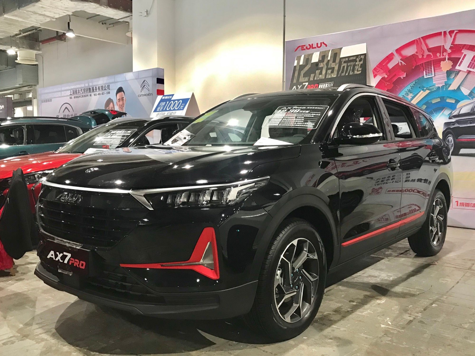 Black 2021 Aeolus AX7 Pro with red trim accents on an indoor display, front three-quarter view