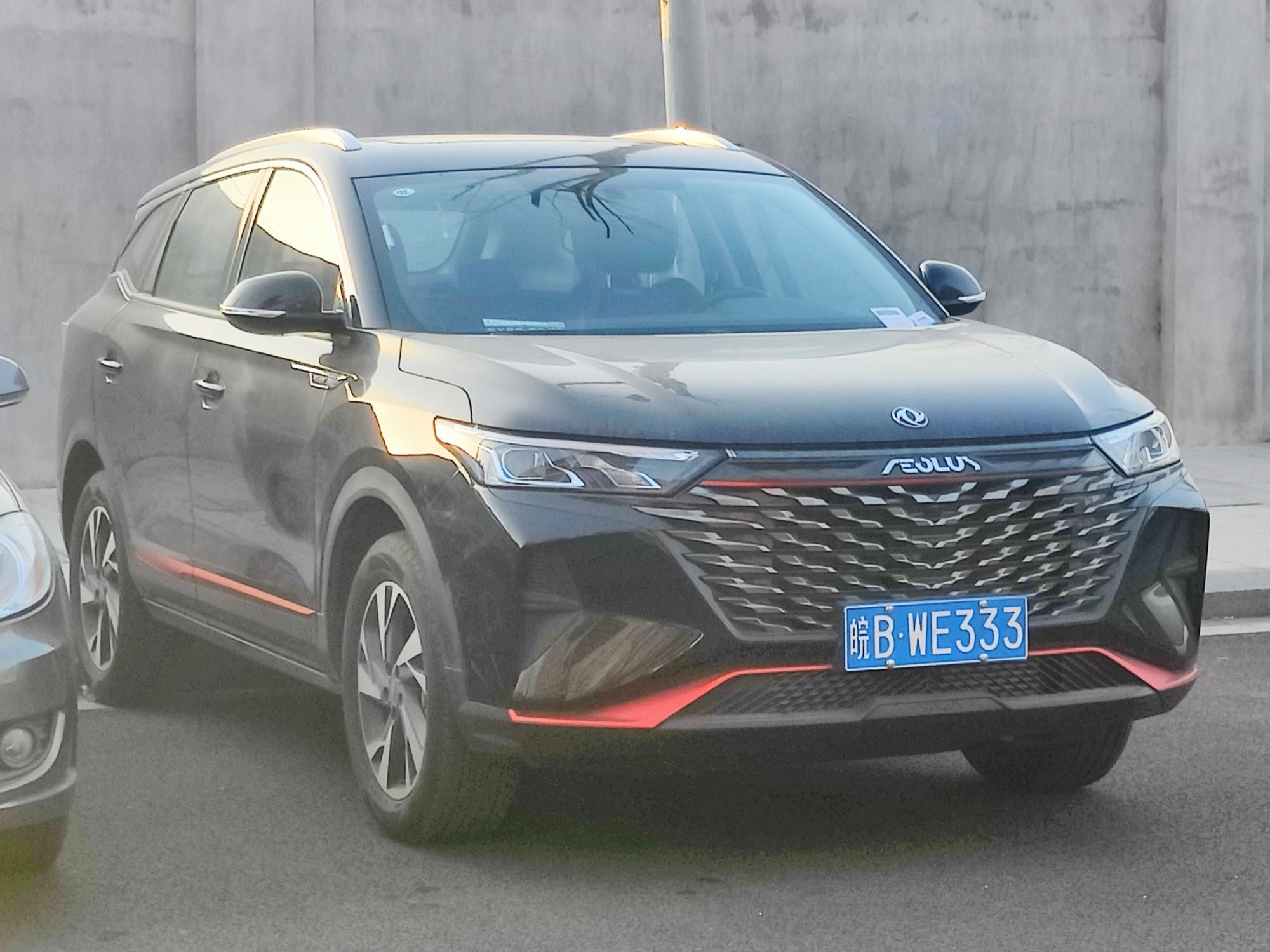 Dark grey 2022 Aeolus AX7 Plus parked on a street, front three-quarter view