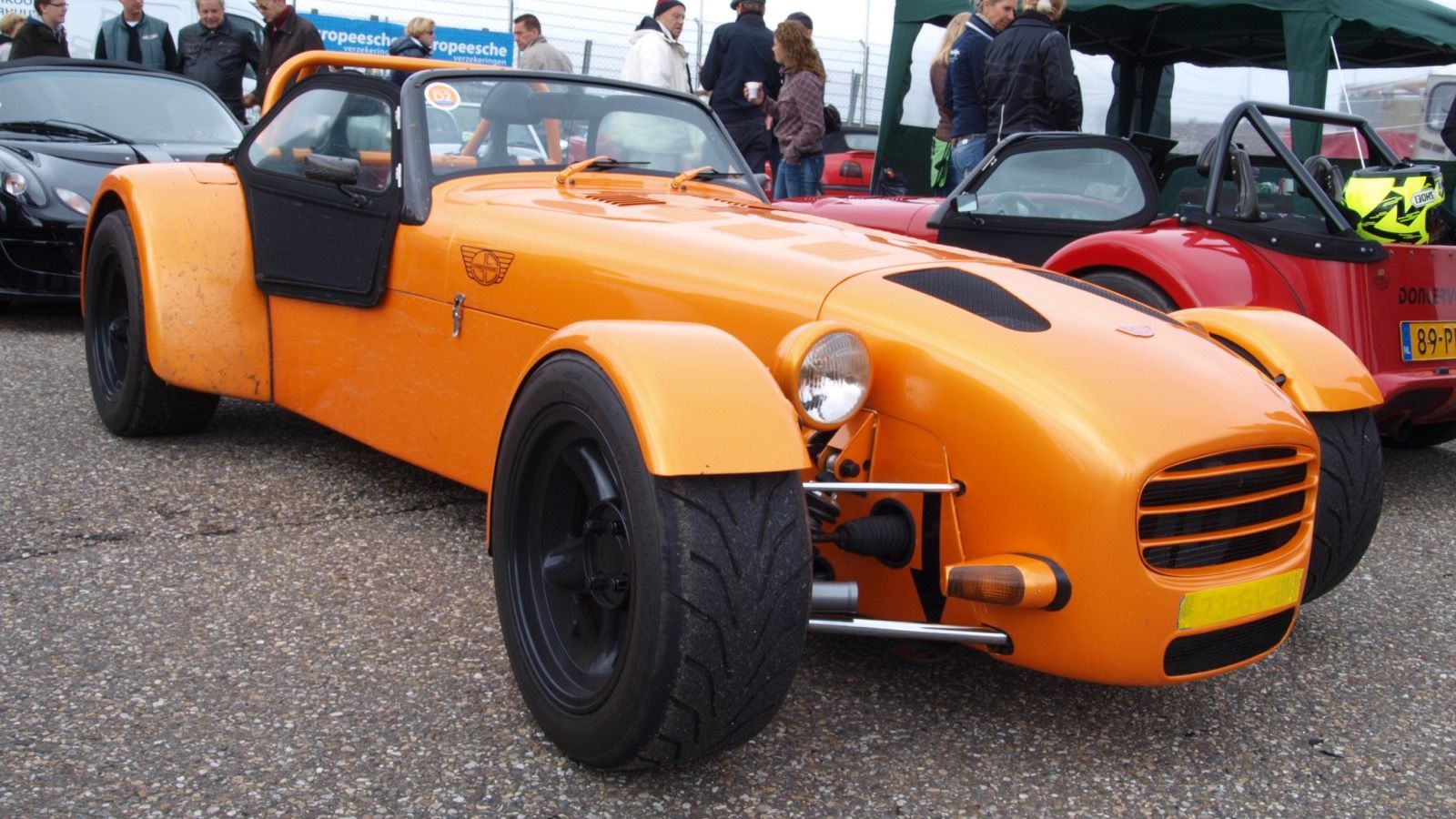Orange Donkervoort D8 Zetec roadster with exposed front suspension, front three-quarter view
