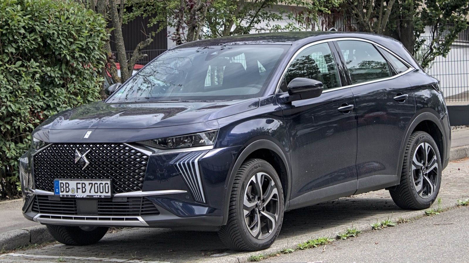 Dark blue 2022 DS 7 SUV with diamond-motif grille, front three-quarter view