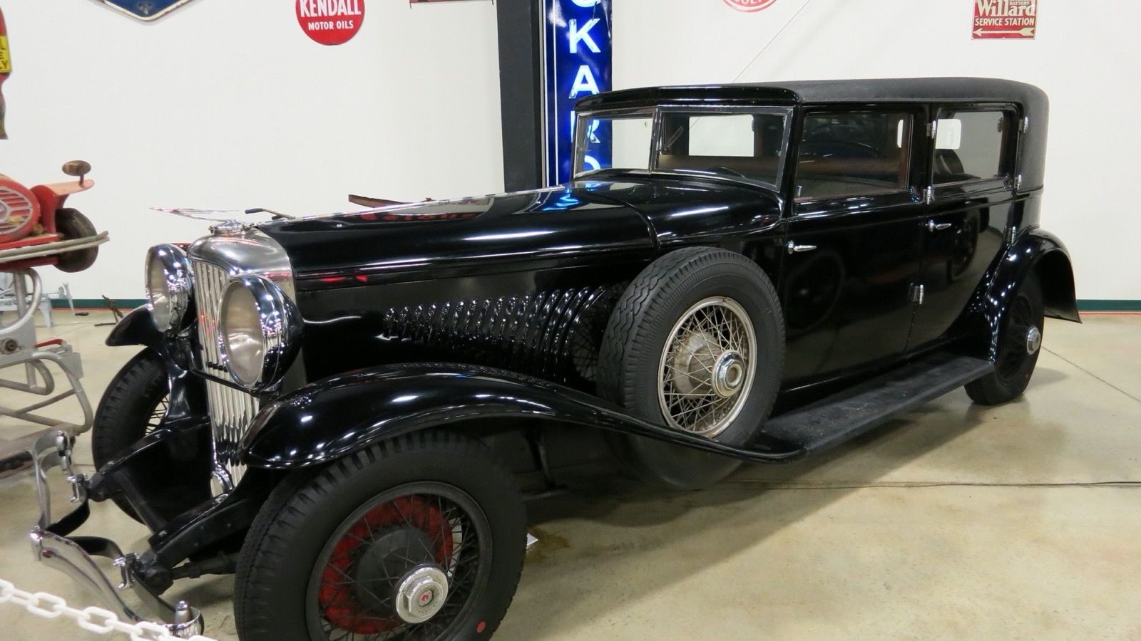 Black 1929 Duesenberg Model J sedan, front-left three-quarter view