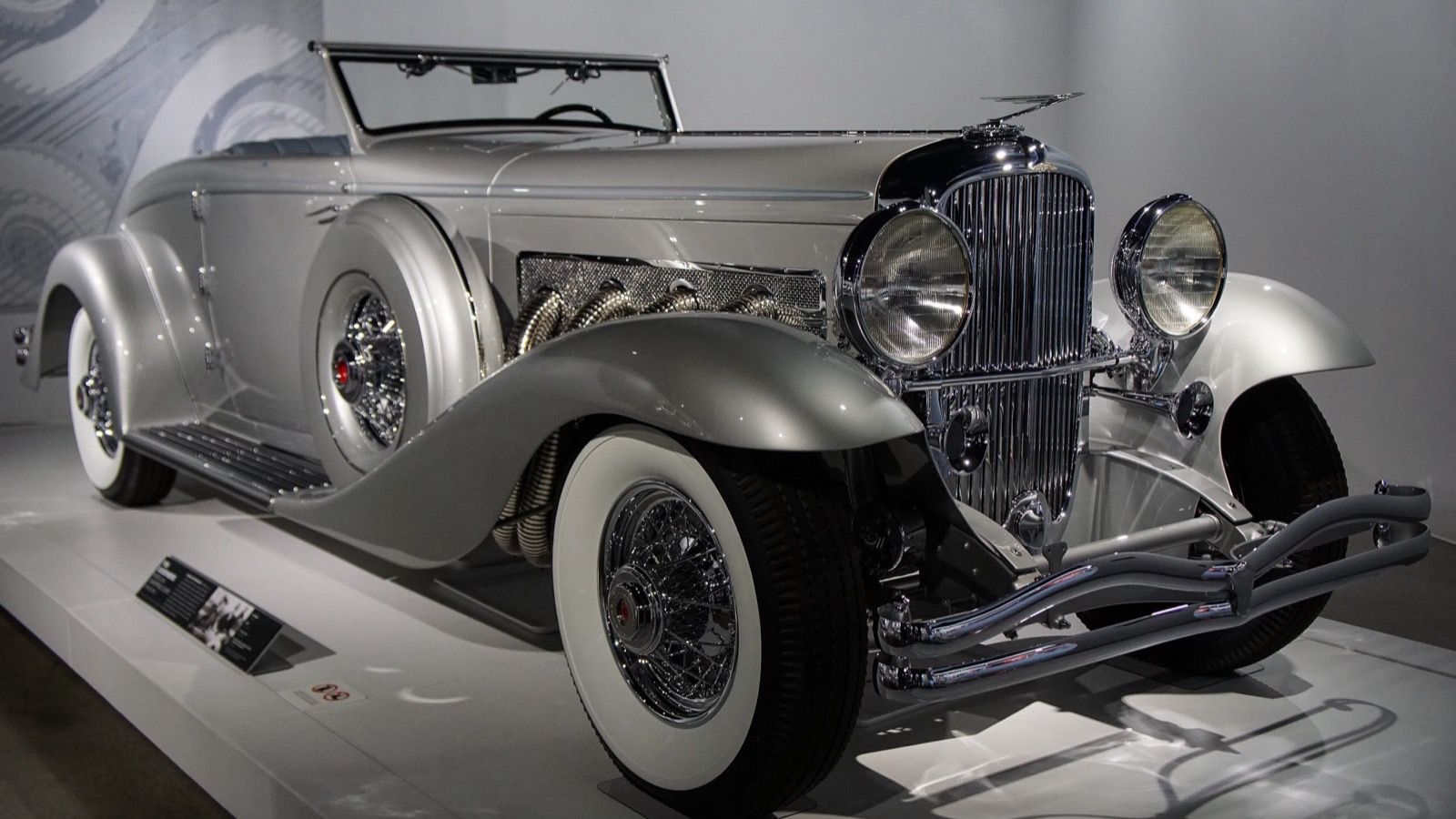 Silver 1933 Duesenberg SJ roadster with external exhaust, front-right three-quarter view