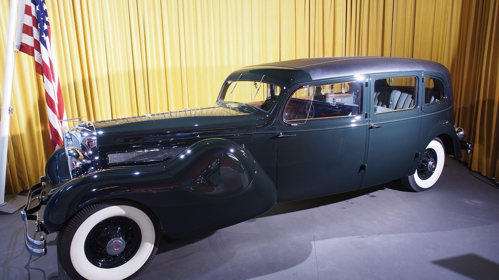 Dark green 1937 Duesenberg Model J limousine landaulette, side profile view