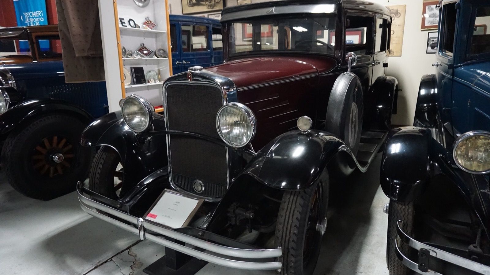 Maroon and black 1930 Durant Model 6-14 four-door sedan with side-mounted spare wheel, front three-quarter view