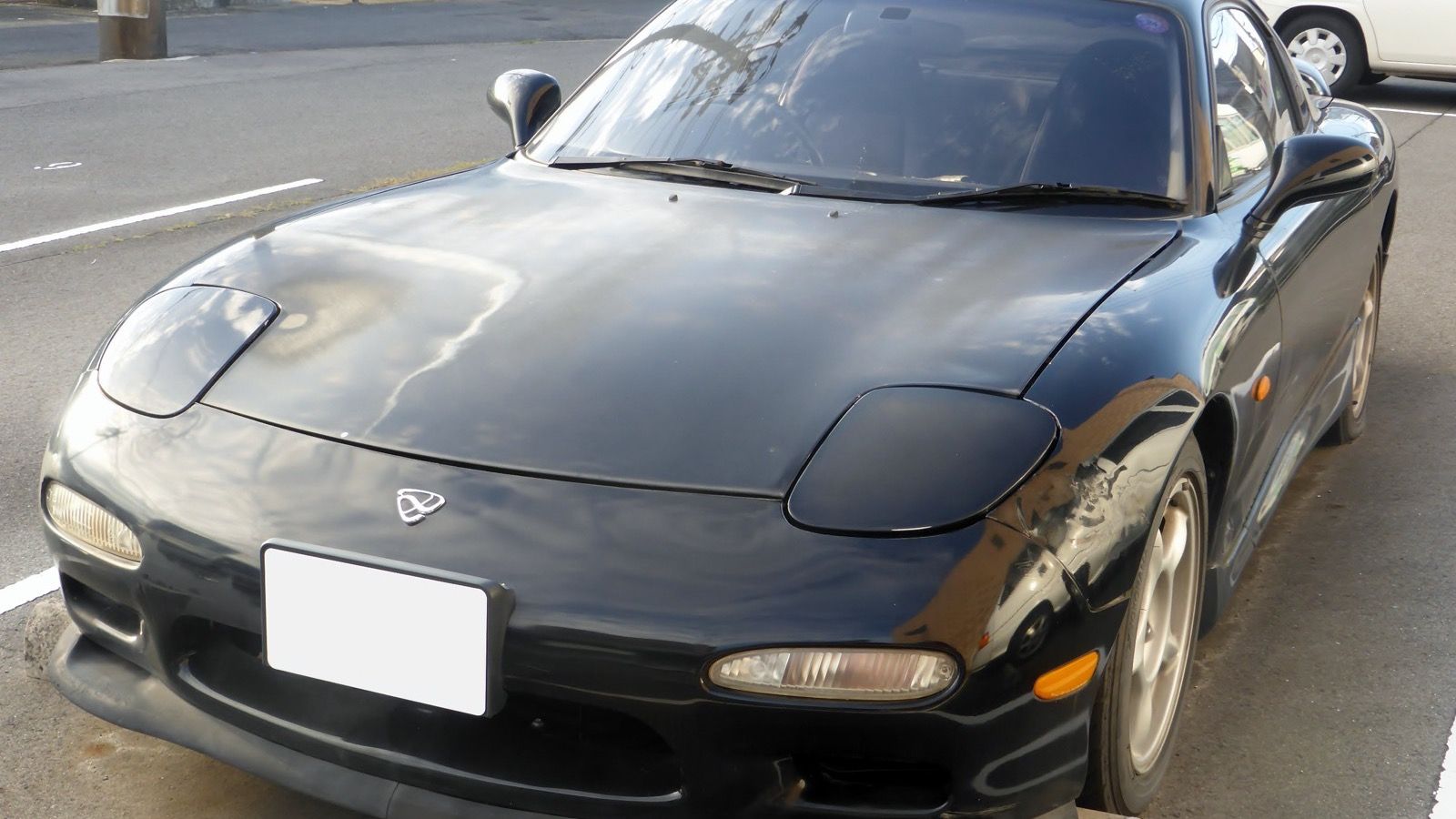 Black 1993 ɛ̃fini RX-7 Type RS (FD3S), front view showing the pop-up headlights closed