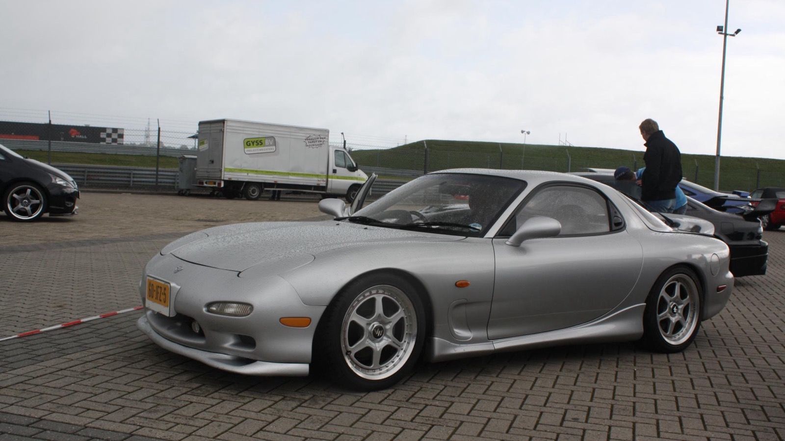 Silver ɛ̃fini RX-7 Type R2 (E-FD3S), front three-quarter view at a circuit paddock