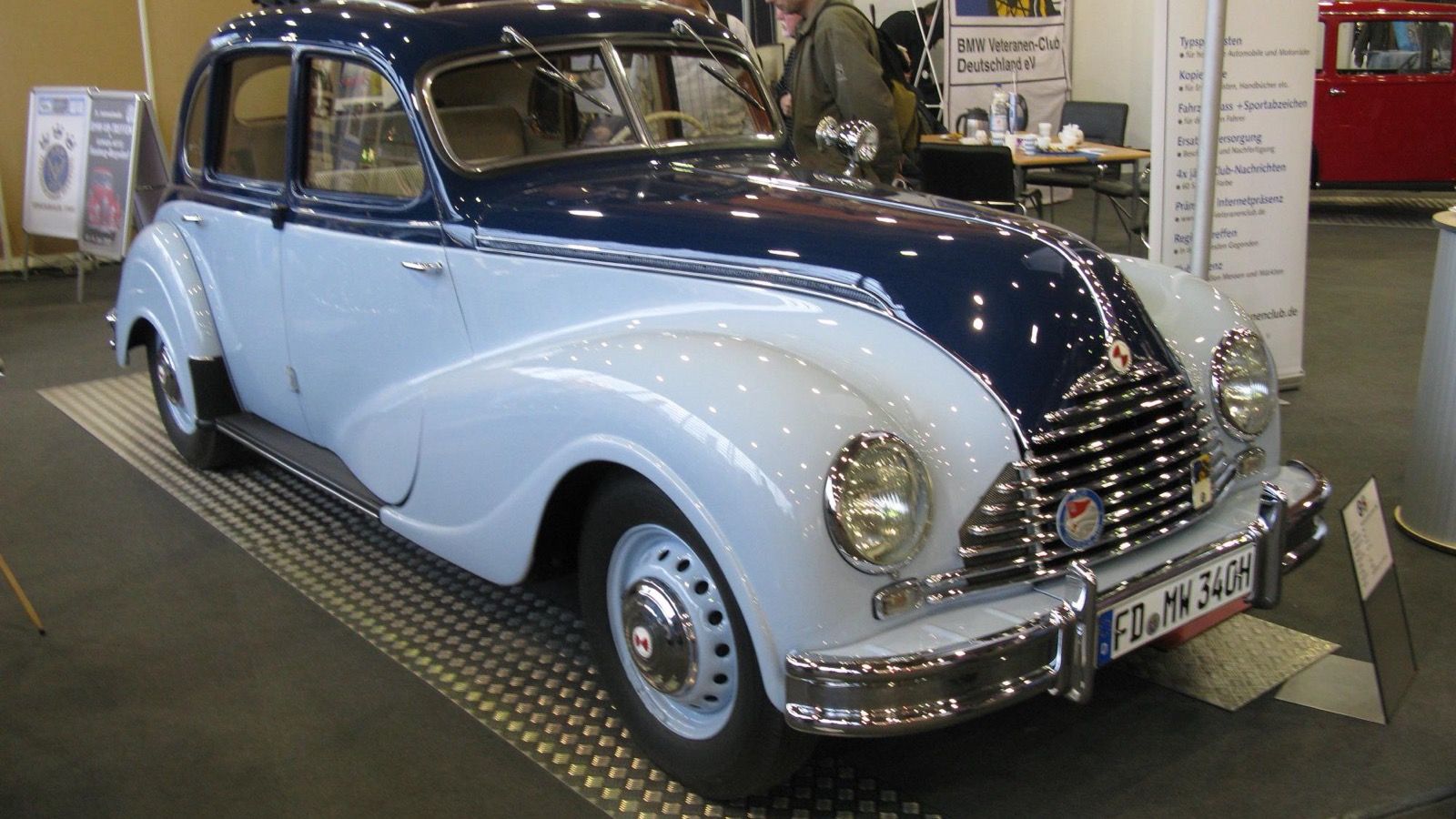 Two-tone blue 1955 EMW 340-2 four-door saloon at an indoor show, front three-quarter view
