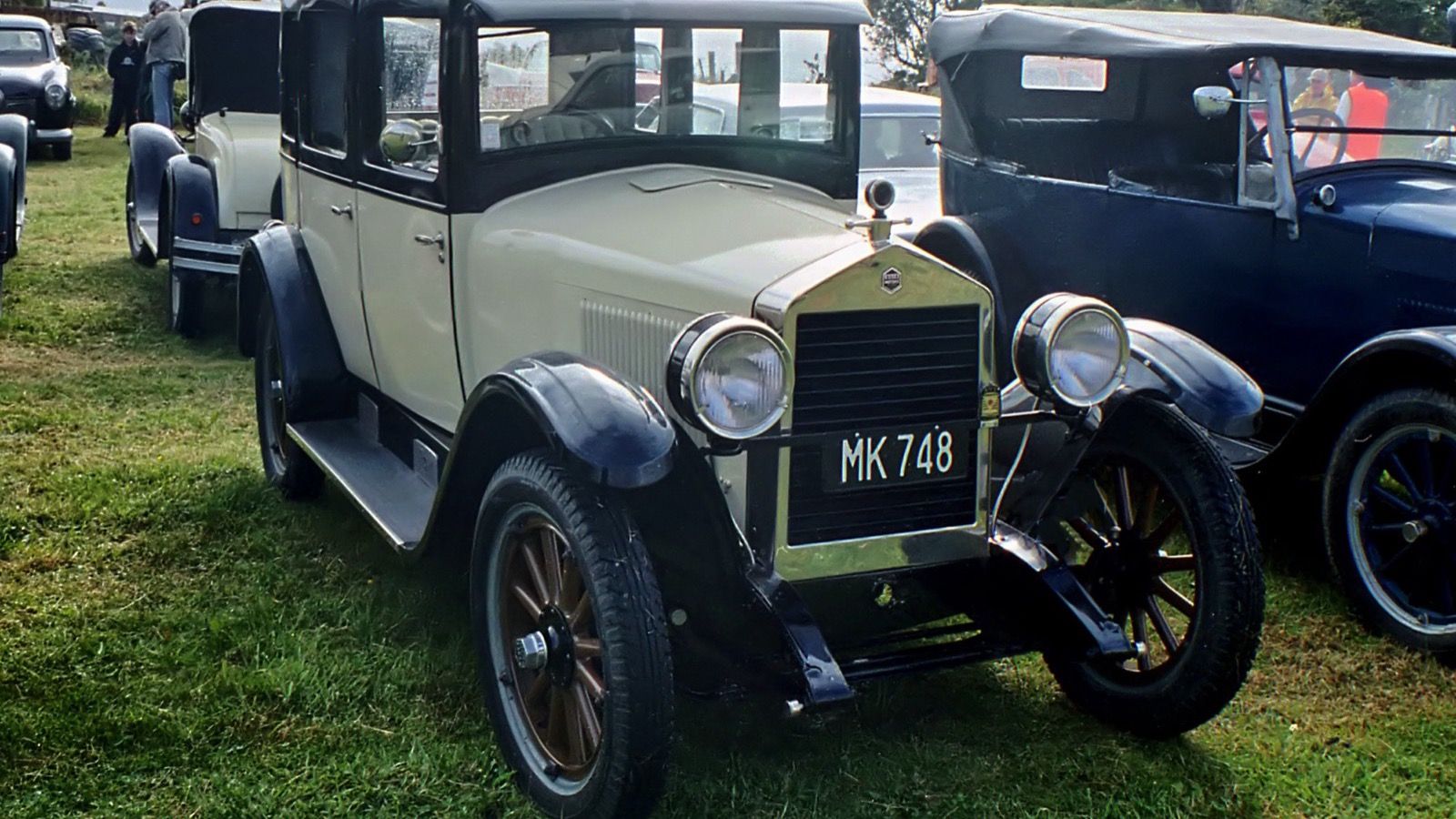 Cream and black 1926 Essex closed sedan on grass at a car show, front three-quarter view