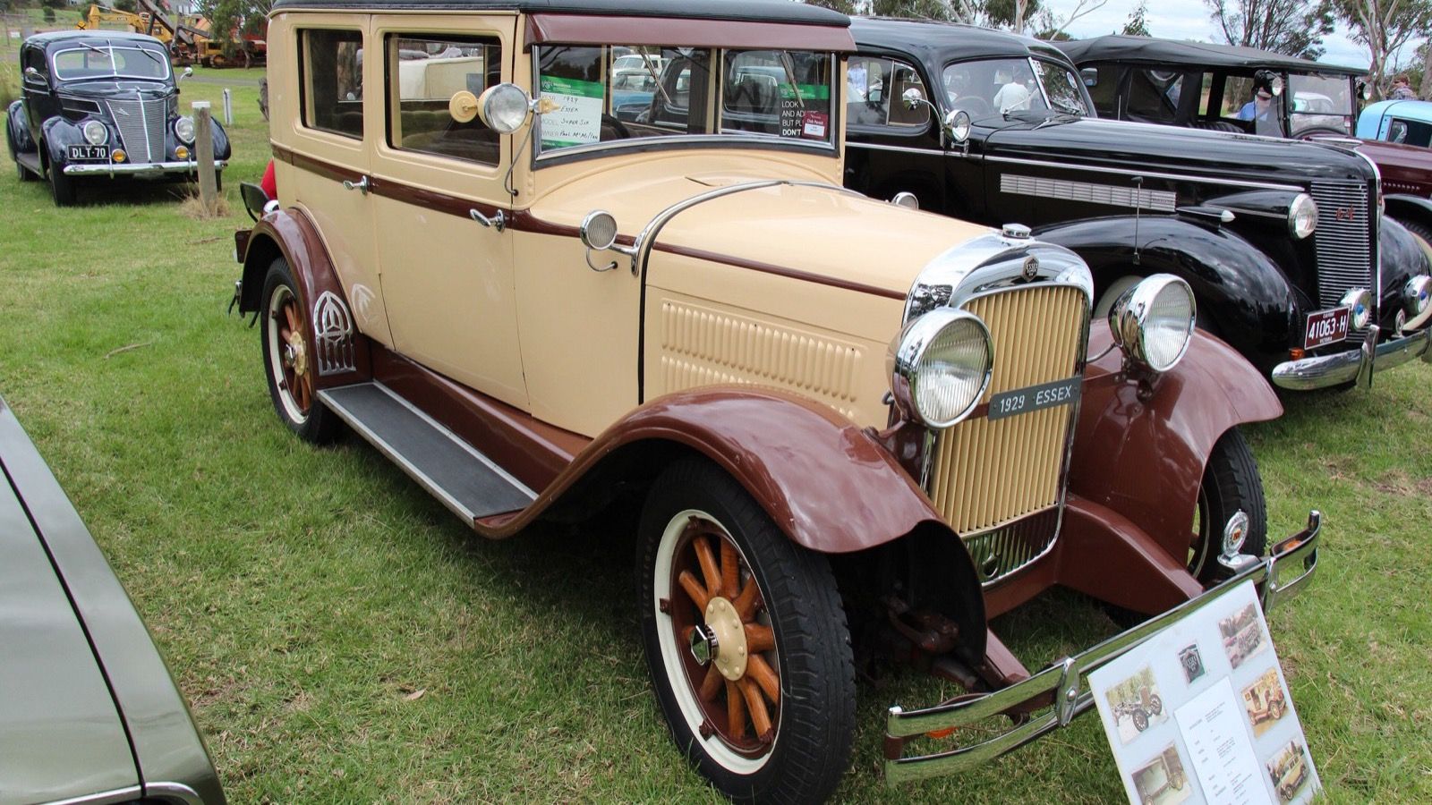 Cream and maroon 1929 Essex Super Six sedan on grass at a car show, front three-quarter view