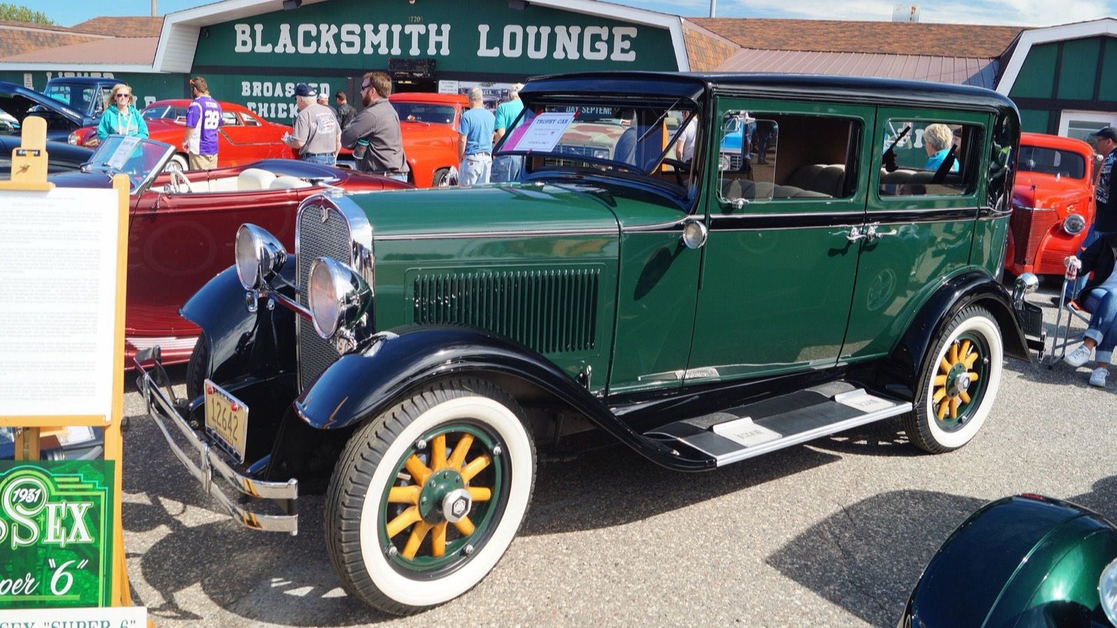 Green and black 1931 Essex Super Six sedan with yellow wheels at a car show, front three-quarter view