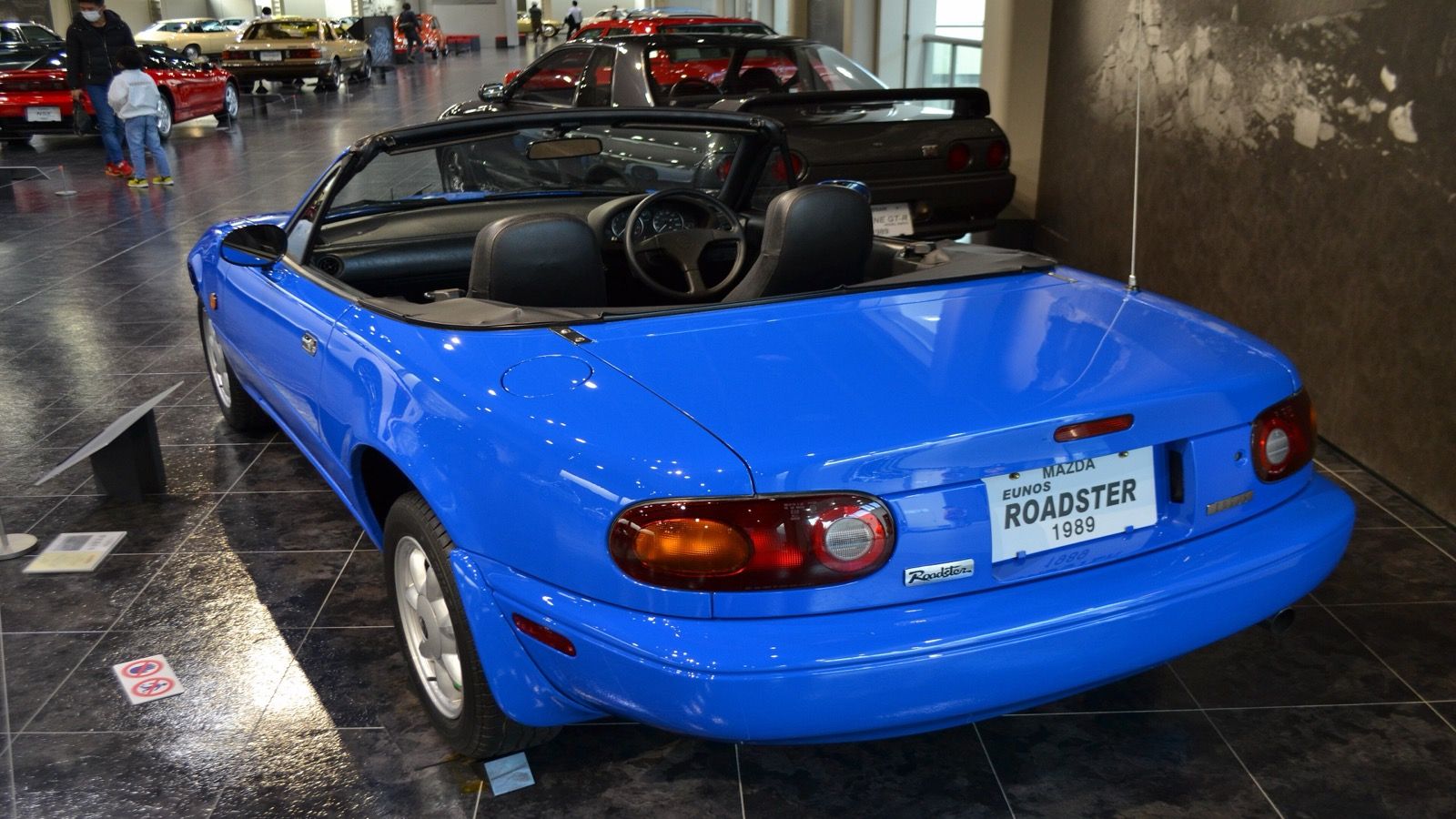 1989 Eunos Roadster in blue with the roof down, rear three-quarter view