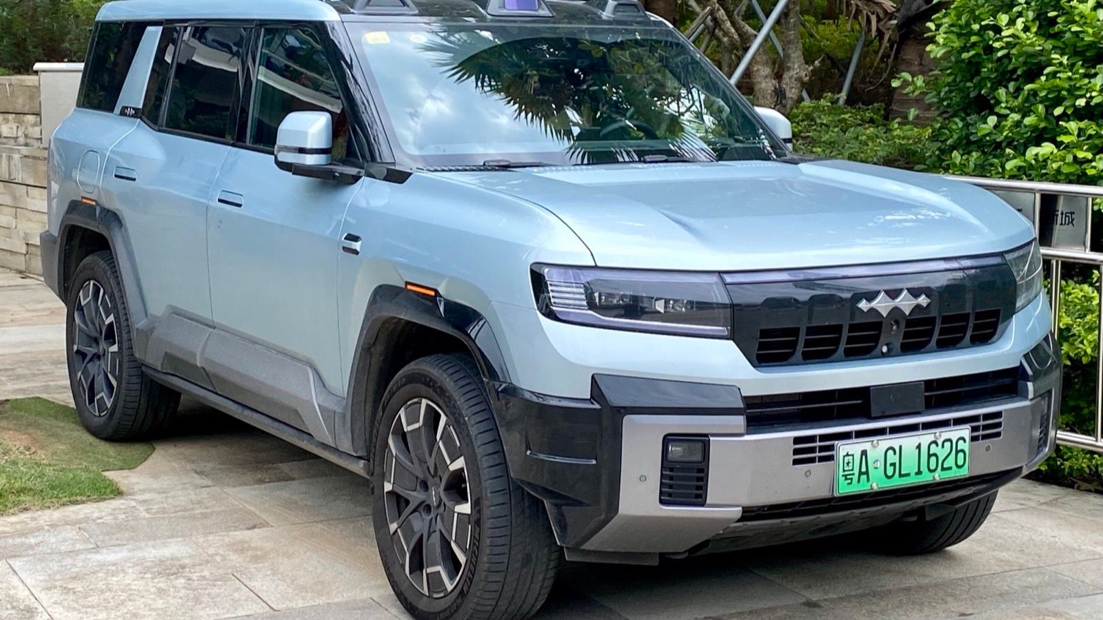 Light-blue Fang Cheng Bao Bao 8 full-size PHEV SUV parked outdoors, front three-quarter view