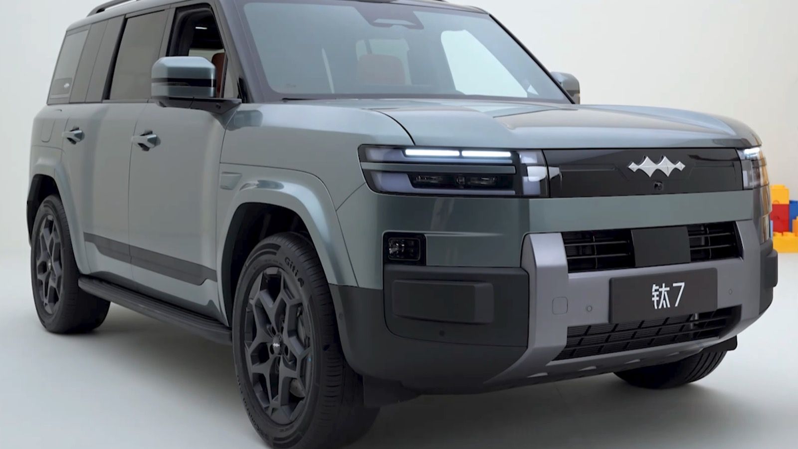 Grey-green Fang Cheng Bao Ti7 SUV in a studio, front three-quarter view
